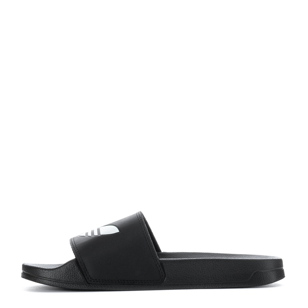 Person walking on the beach wearing adidas Adilette Lite slides for comfort and style