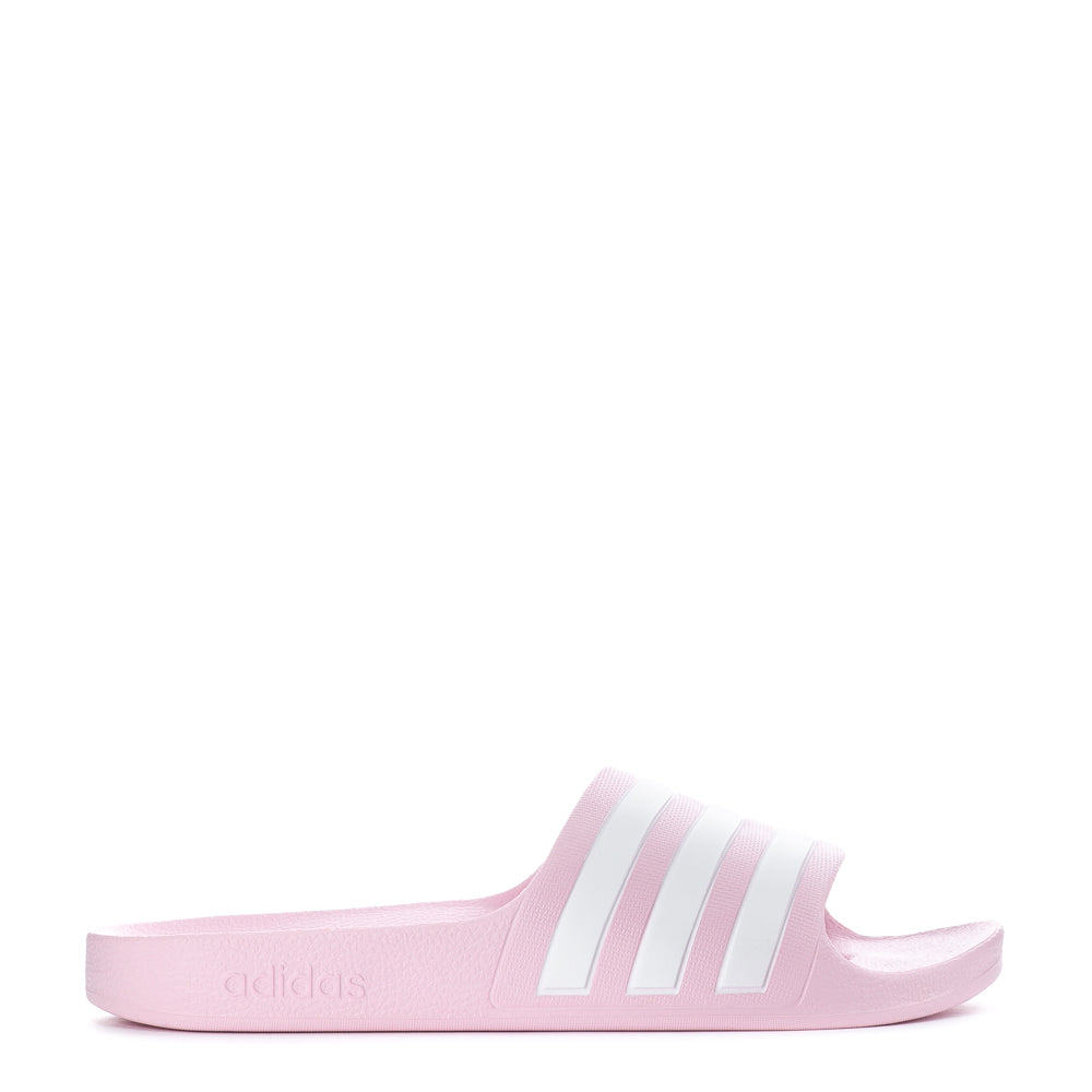 Adidas Adilette Aqua youth slide sandals in a sunny outdoor setting, perfect for summer wear.