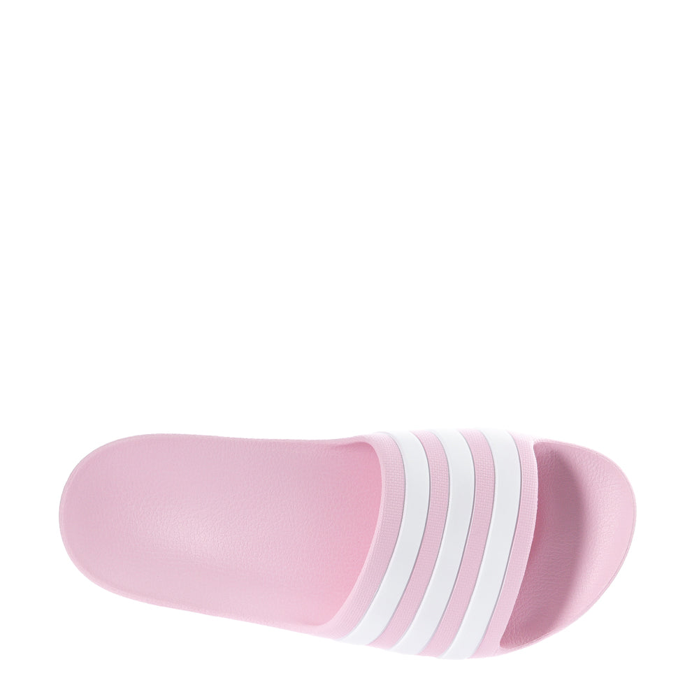 Adidas Adilette Aqua youth slide sandals in a sunny outdoor setting, perfect for summer wear.