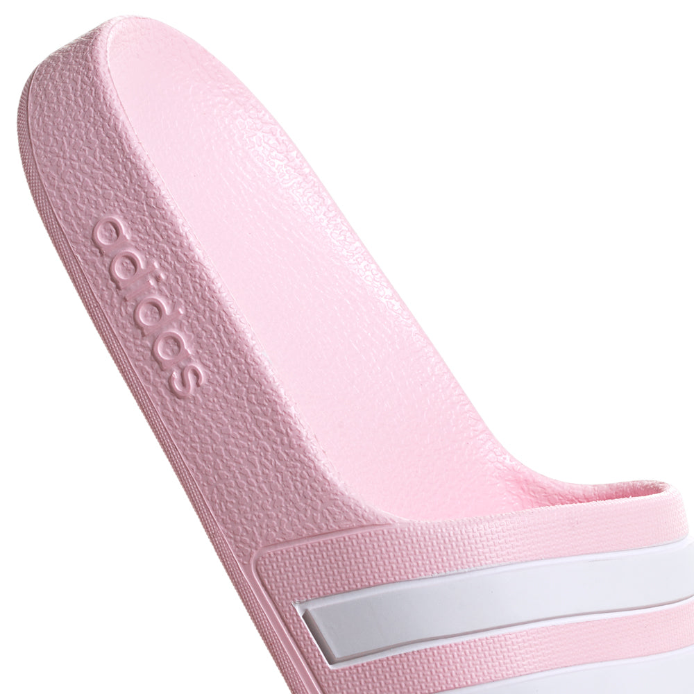 Adidas Adilette Aqua youth slide sandals in a sunny outdoor setting, perfect for summer wear.