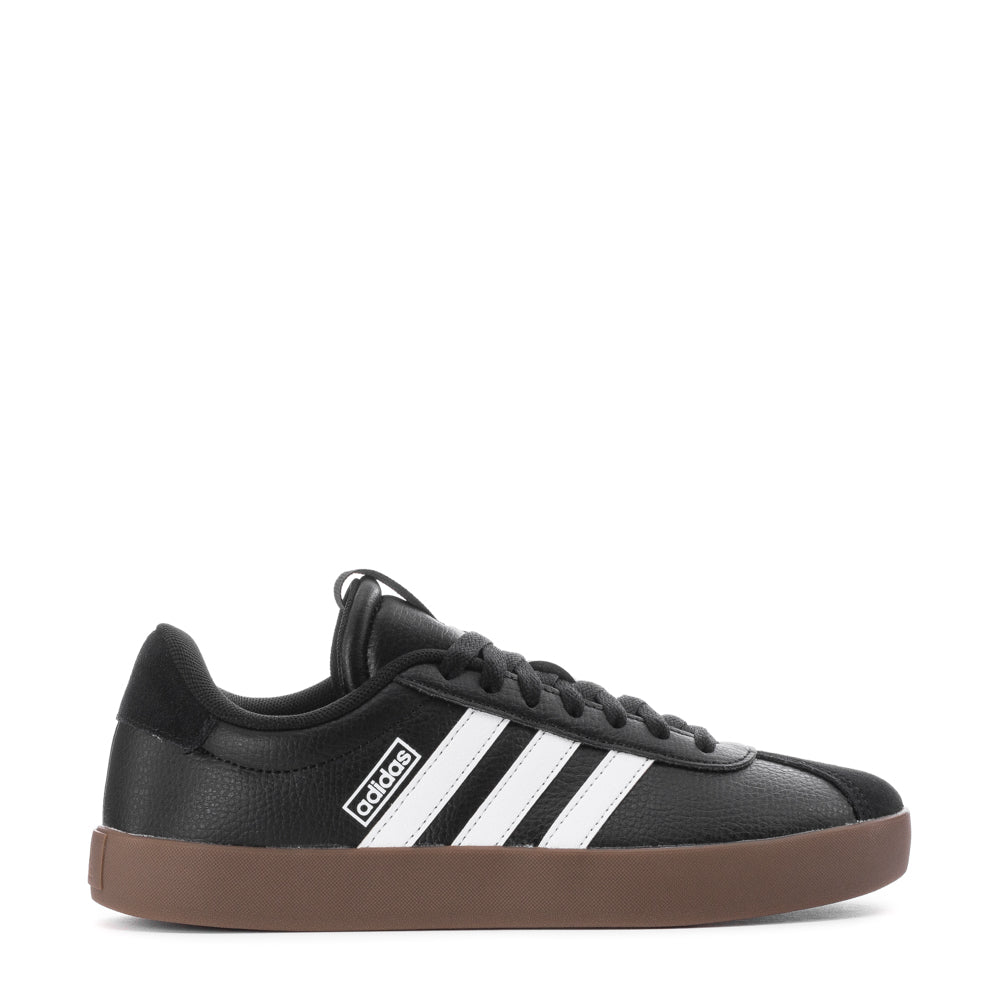 Side angle of white adidas VL Court 3.0 skate shoes resting on a skateboard deck, highlighting vulcanized outsole