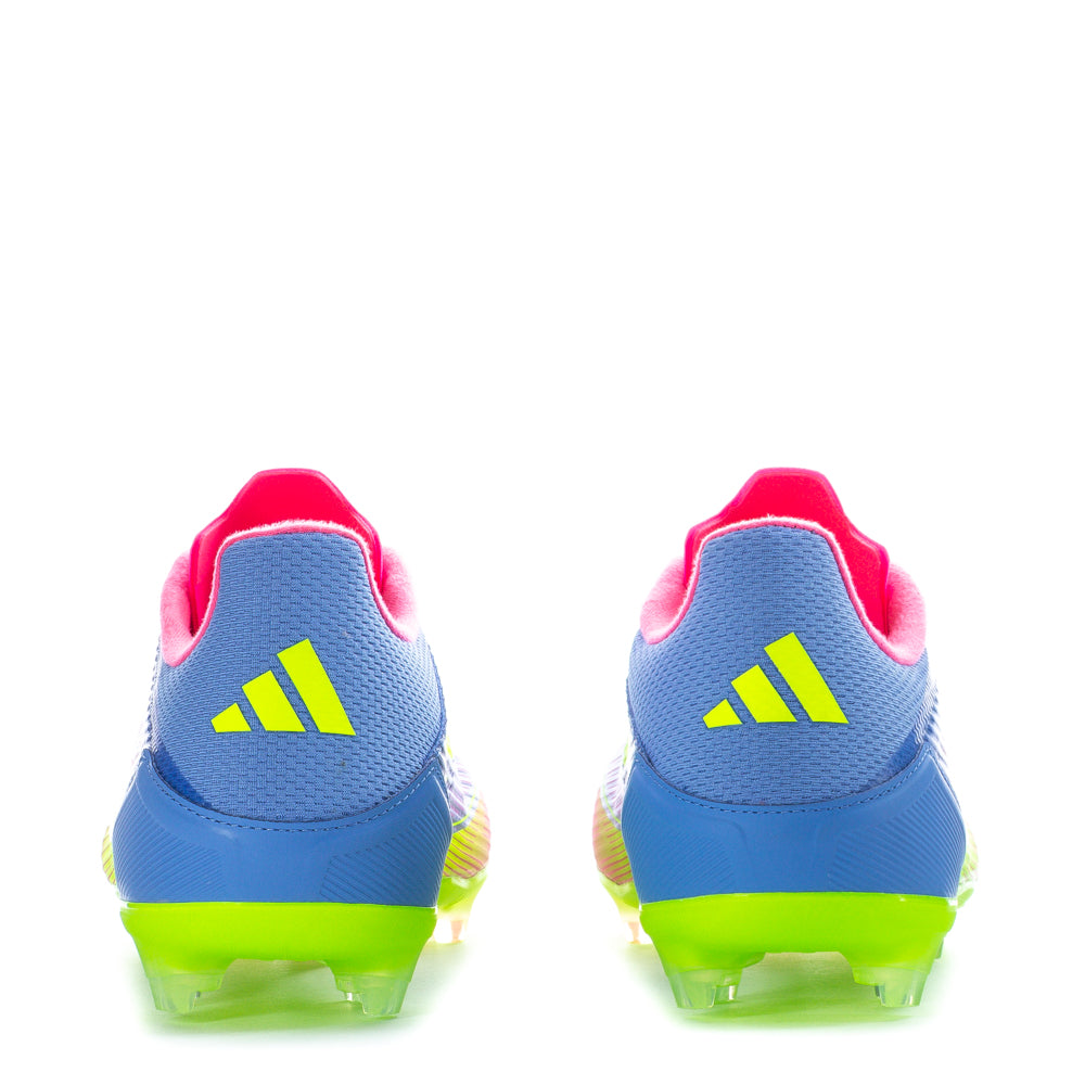 Close-up of adidas F50 League Low FGxMG mens soccer cleats showing stud configuration on dry grass