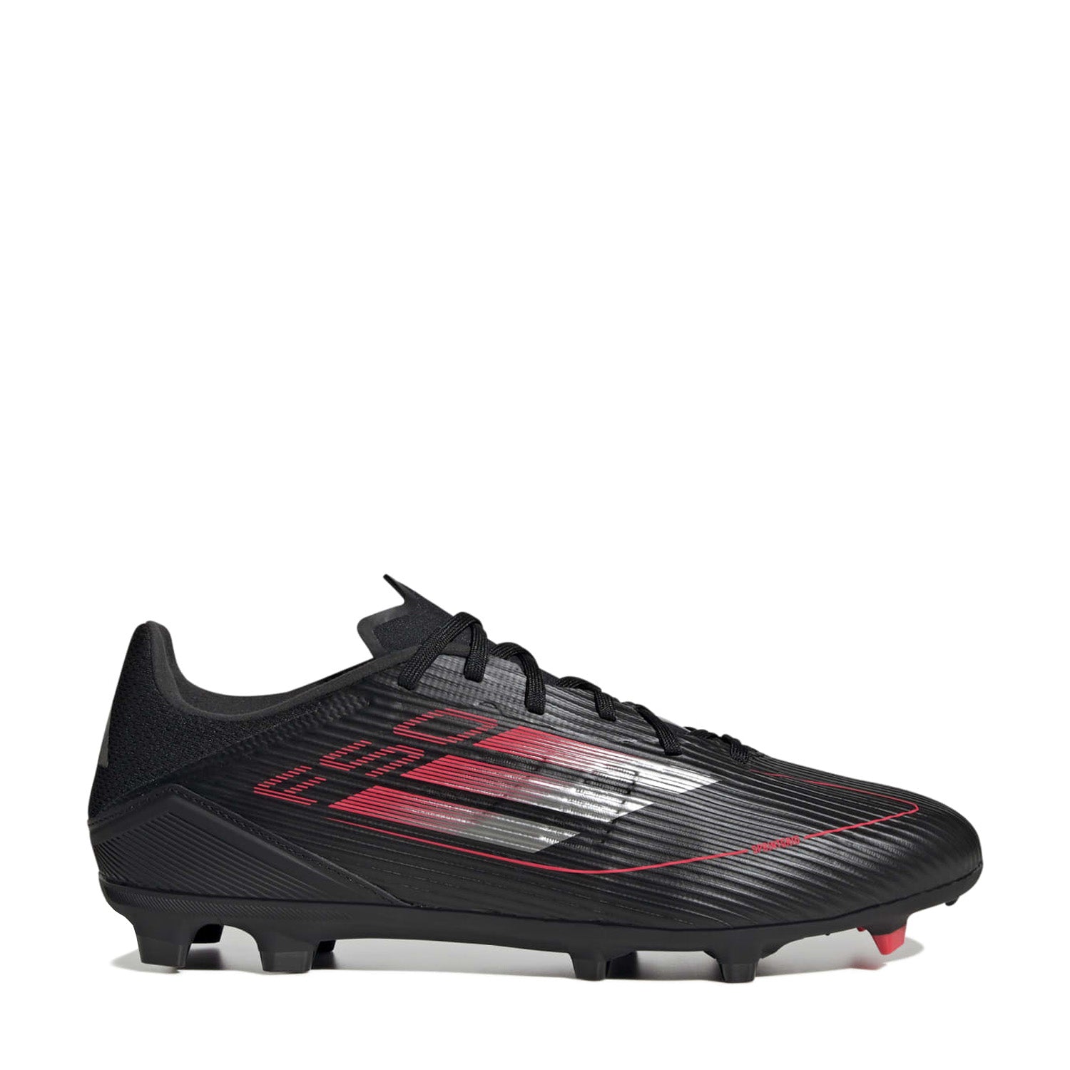 Overhead shot of adidas F50 League Low FGxMG cleats showing hybrid stud layout on dry grass