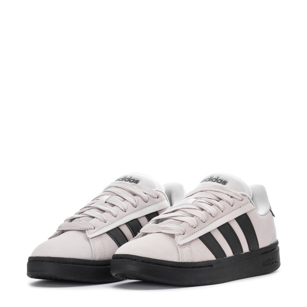 Lifestyle shot of Adidas Grand Court Alpha mens sneakers worn casually in an urban setting.
