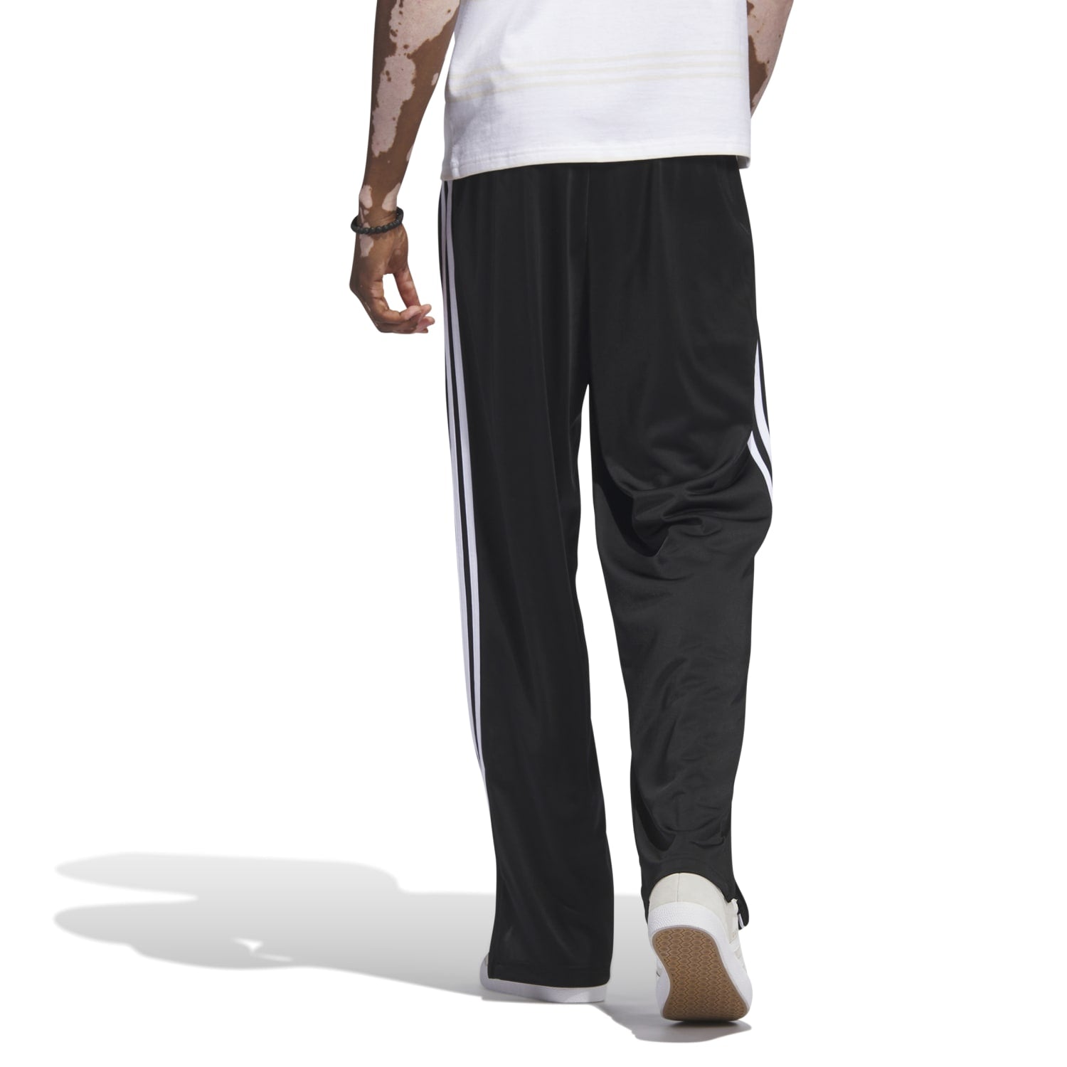 Close-up of lightweight recycled polyester fabric texture against city backdrop, highlighting durability of track pants