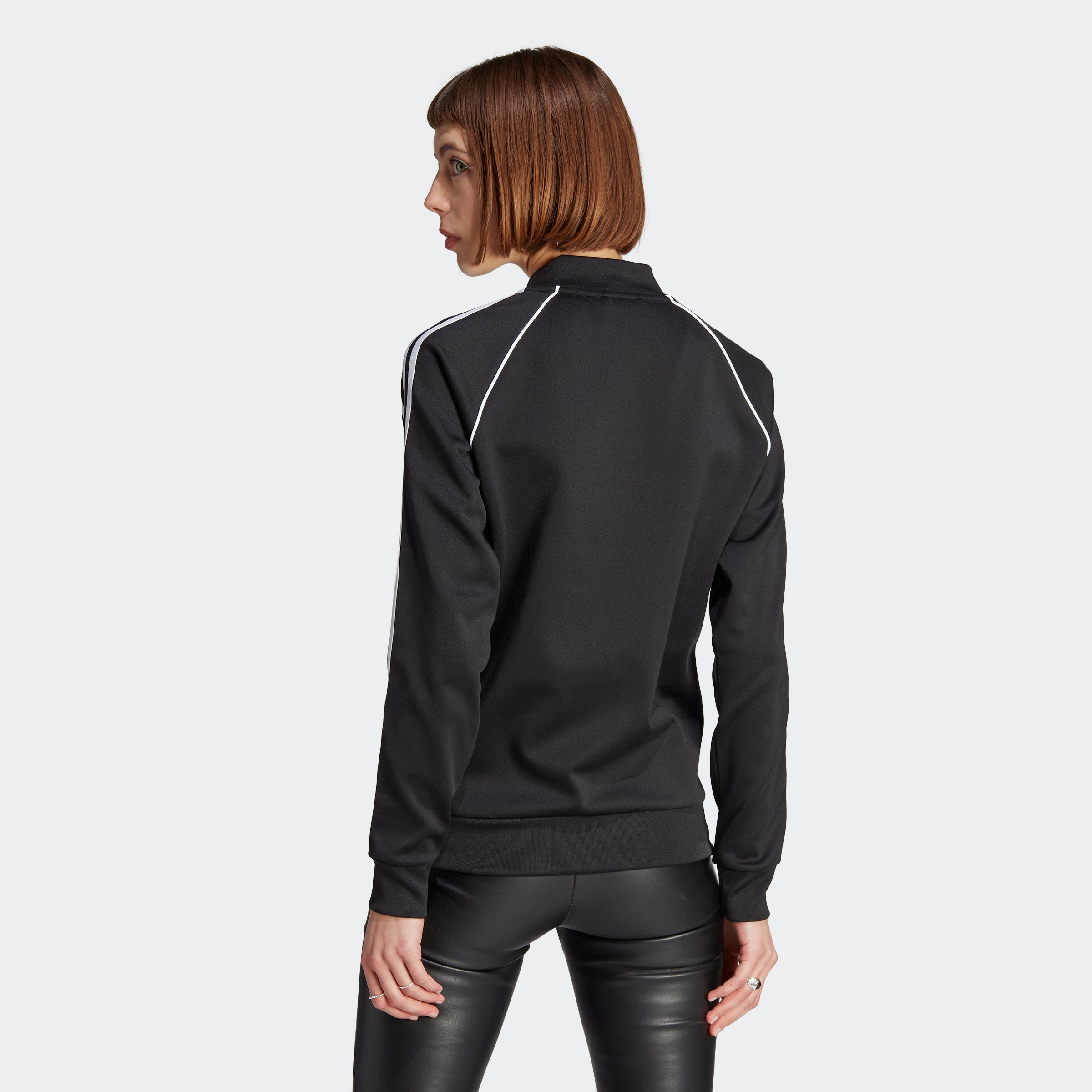 Adidas Superstar womens track jacket, front view, showcasing the full zip and stylish ribbed collar.