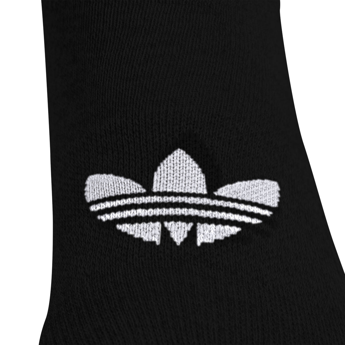 Flat-lay of six pairs of adidas superlite no-show socks in grey, black, and white on wood floor