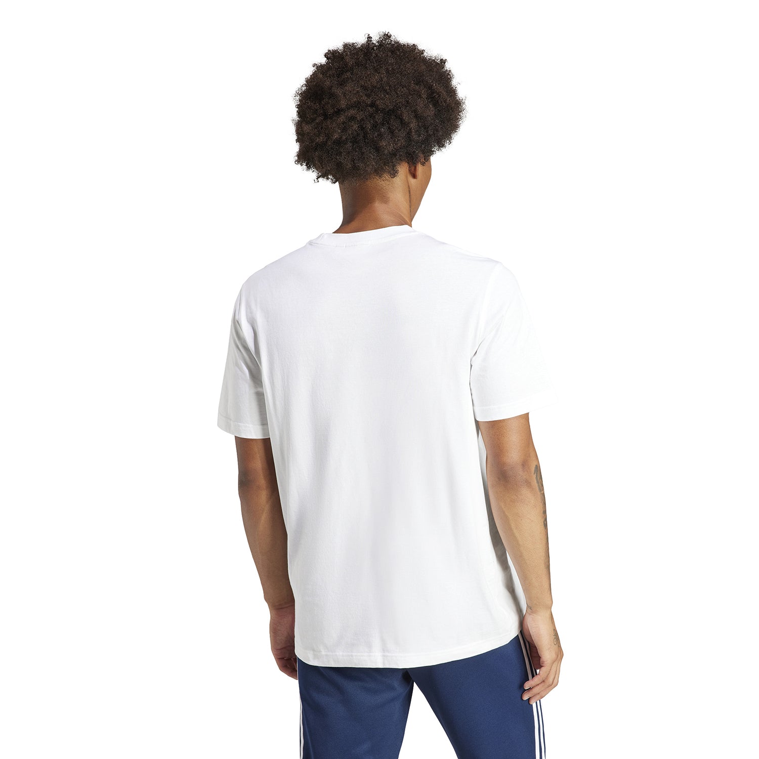 Lifestyle shot of a man wearing the Adidas Trefoil tee, paired with shorts and a jacket for a casual look.