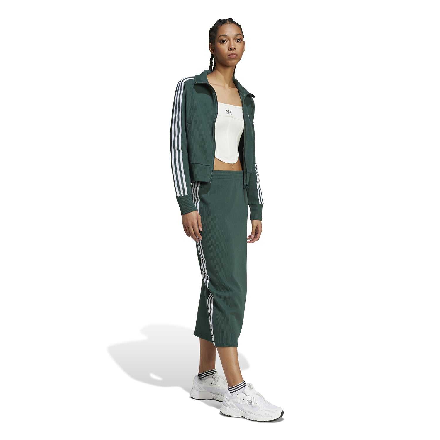 Back view showing the sleek silhouette of the recycled-cotton knitted skirt with three stripes