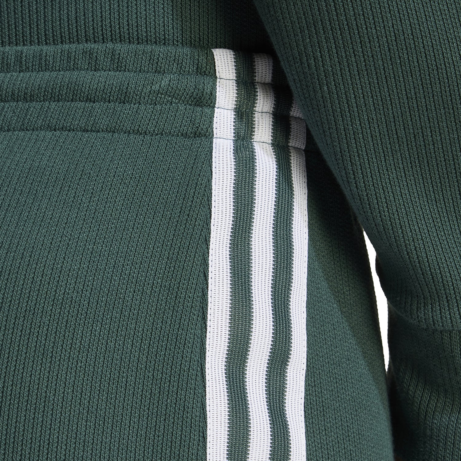 Close-up of the elastic waistband and iconic three-stripe detail on the adidas skirt