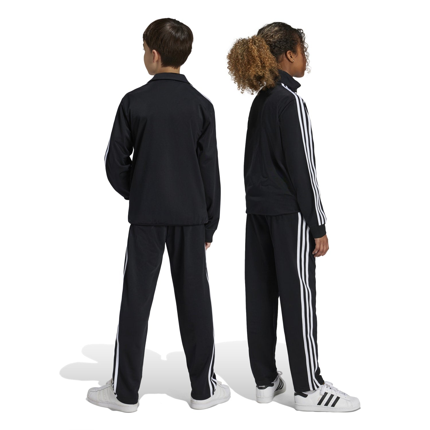 Child playing sports in stylish adidas kids joggers with stripes and vibrant colors