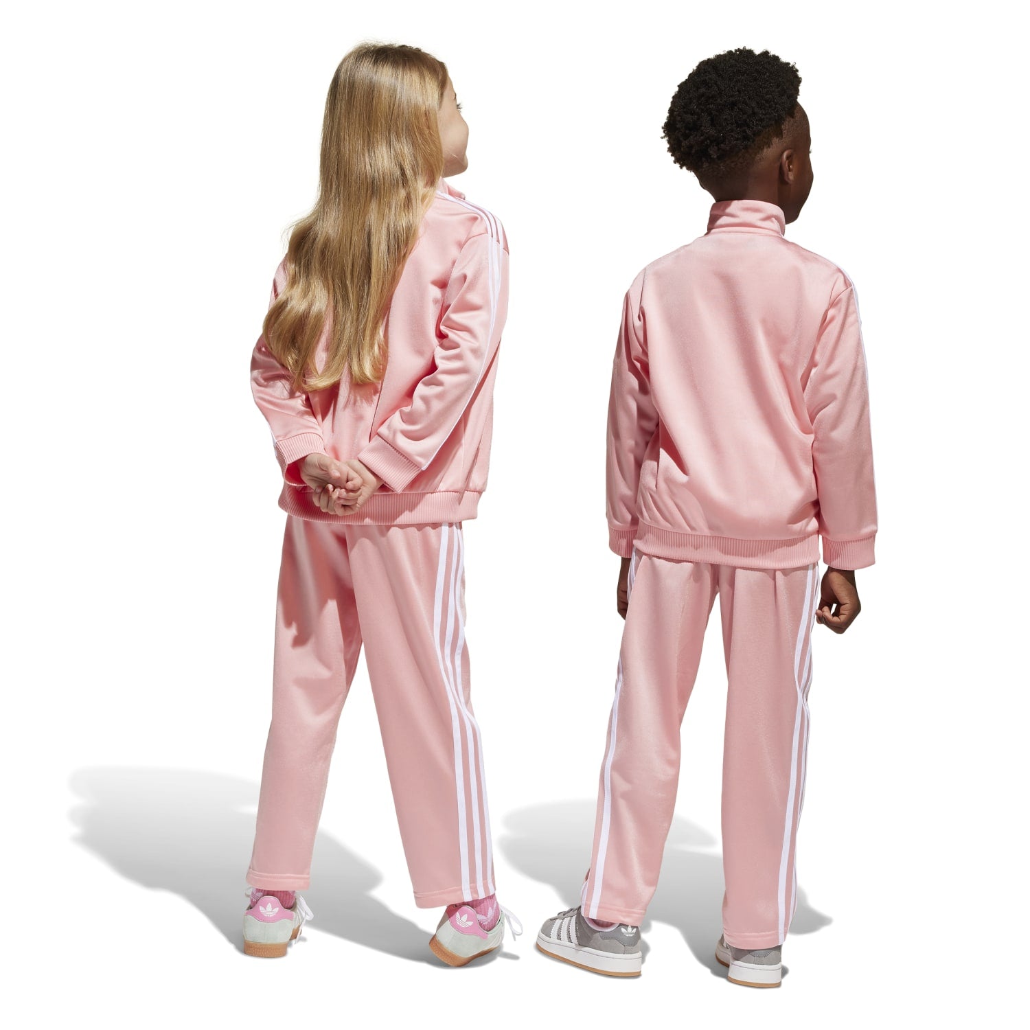 Child running in kids sportswear with zip-up jacket and matching pants