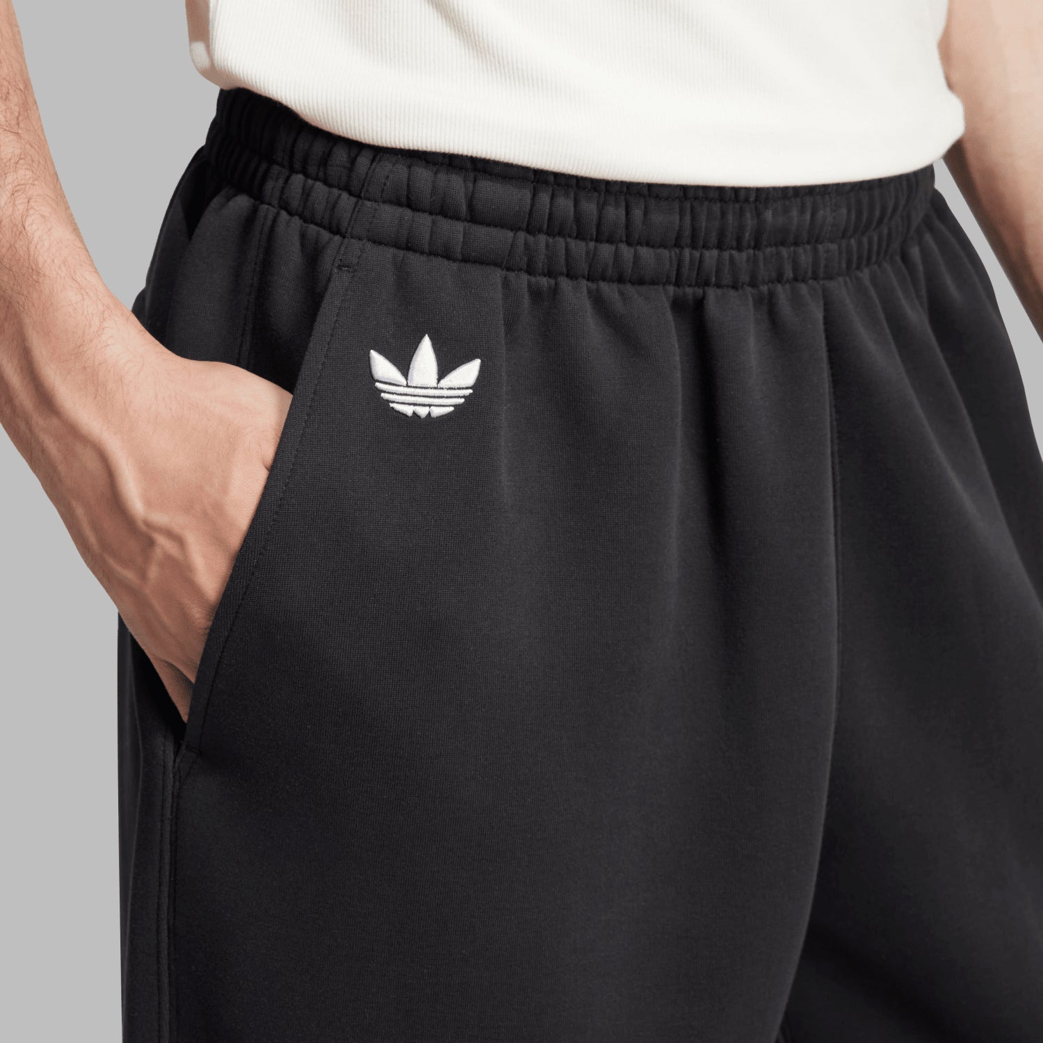 Close-up of mens adidas Neu Classics sweatpants showing the three stripes and logo