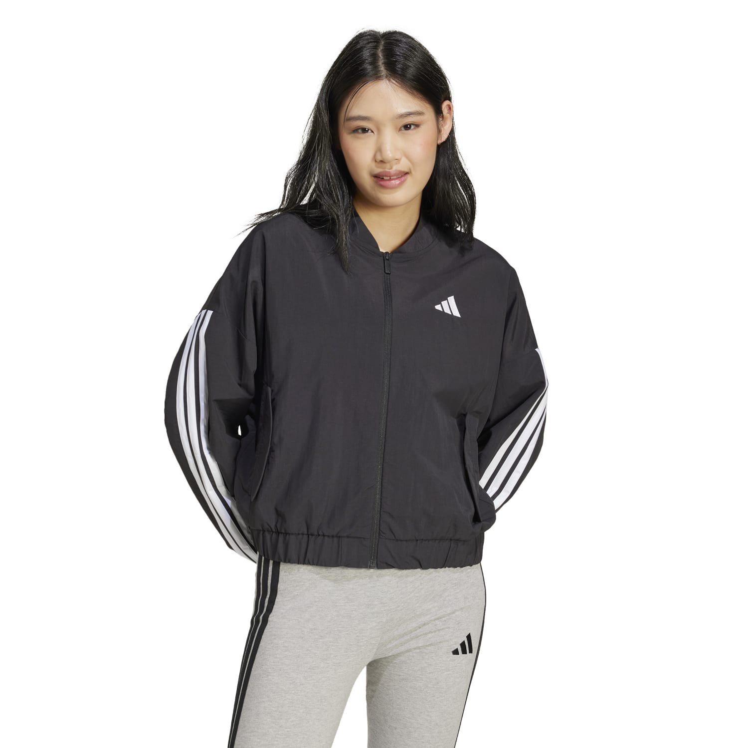 Model walking outdoors wearing a sustainable womens bomber jacket in a casual setting