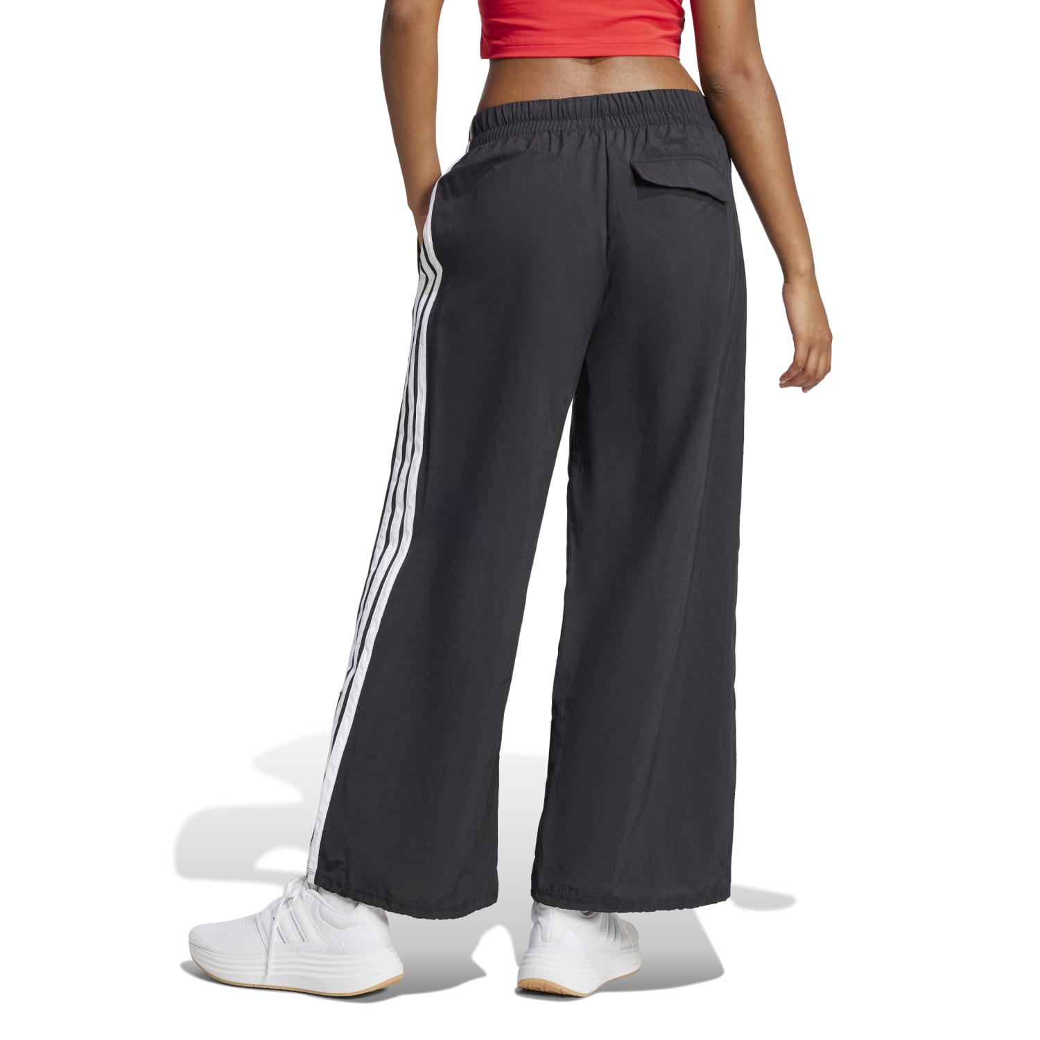 Back view of womens activewear parachute pants with flap pocket detail.