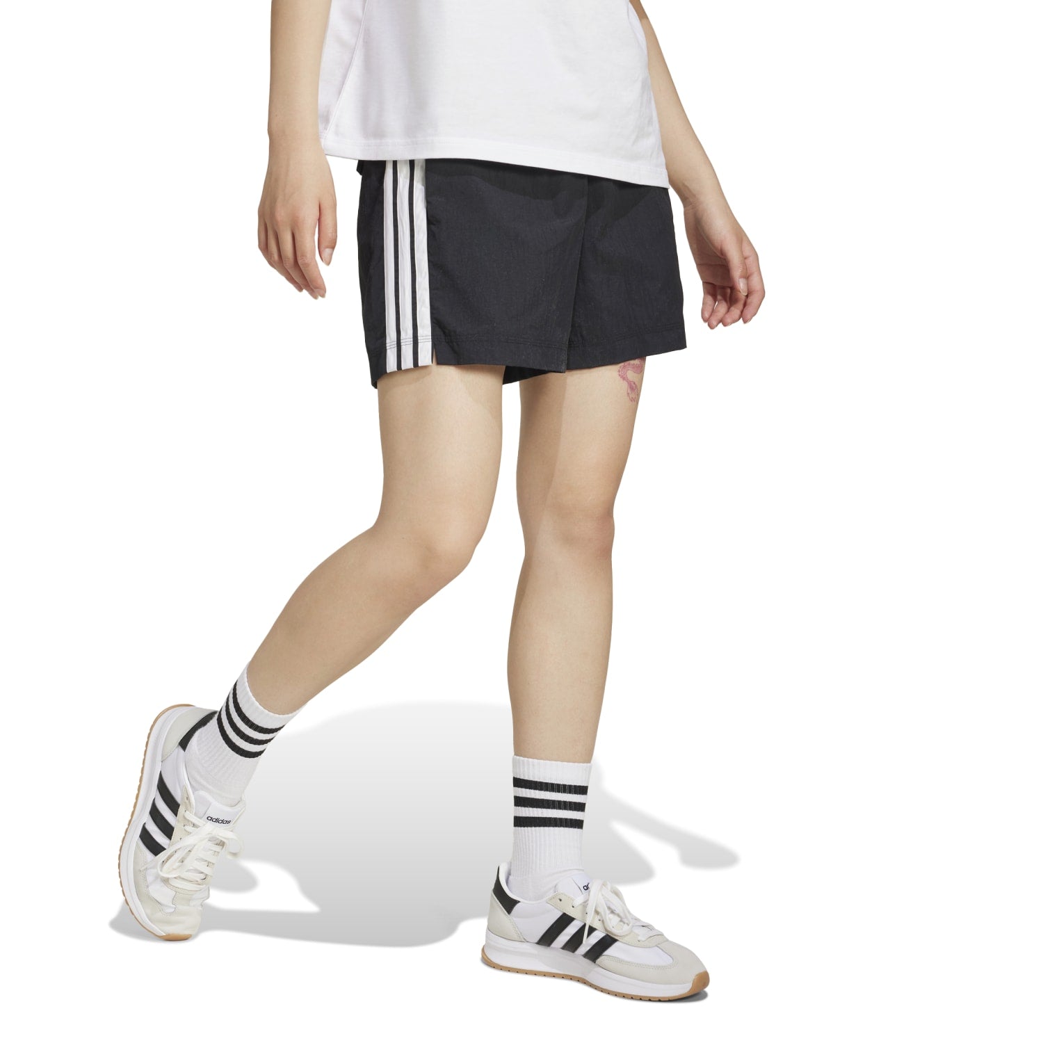 Model wearing Adidas Womens High-Rise 3-Stripe Athletic Shorts during a workout, demonstrating their versatility.