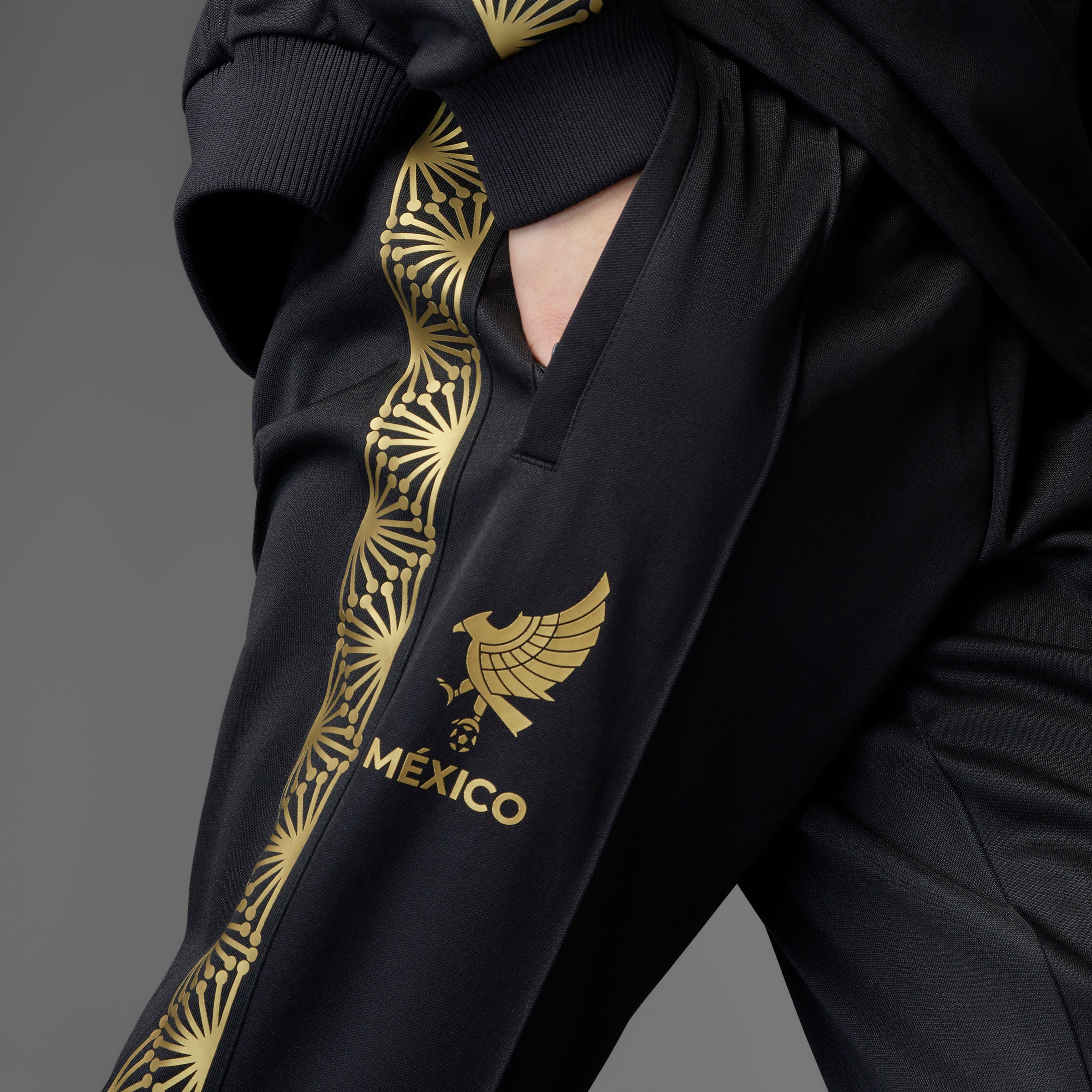 Close-up of the Adidas Mexico soccer track pants showcasing the Trefoil logo and elastic waist with drawcord.