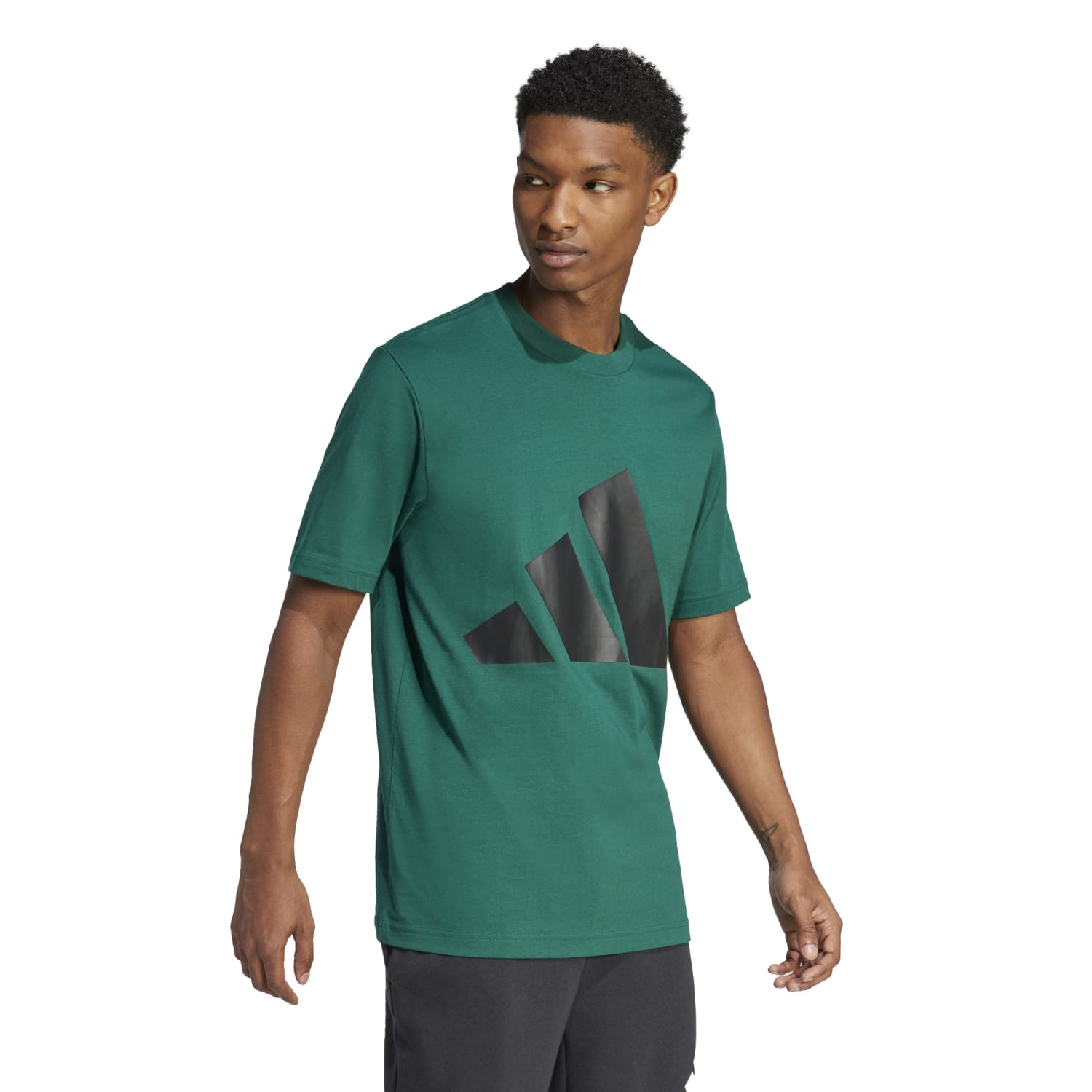 Styled lifestyle shot: man pairing Adidas BOS Tee with joggers and sneakers for sporty street look