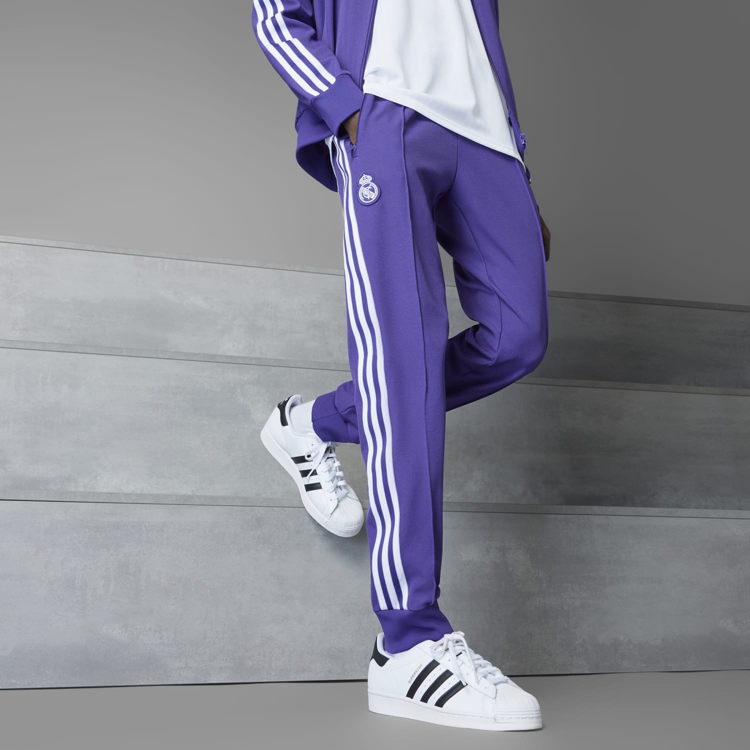 Model wearing Real Madrid Icon track pants in an outdoor setting, perfect for sports and casual wear.