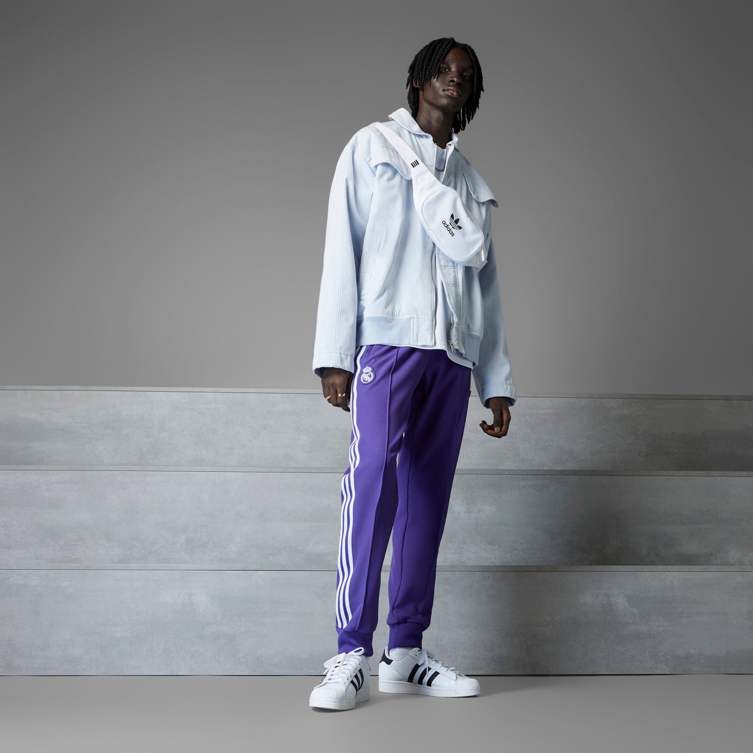 Close-up of Real Madrid track pants featuring sleek design and embroidered crest.