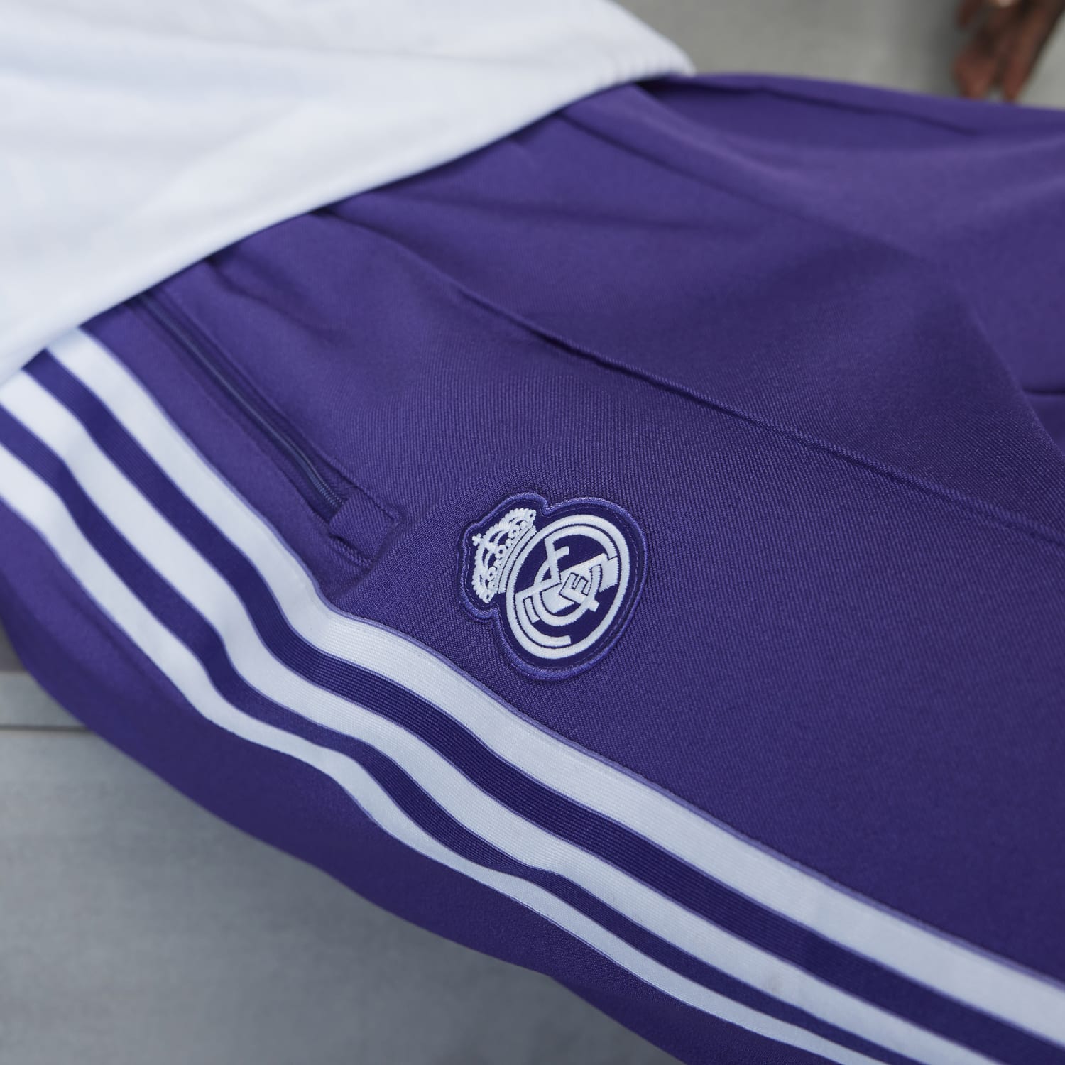 Model wearing Real Madrid Icon track pants in an outdoor setting, perfect for sports and casual wear.