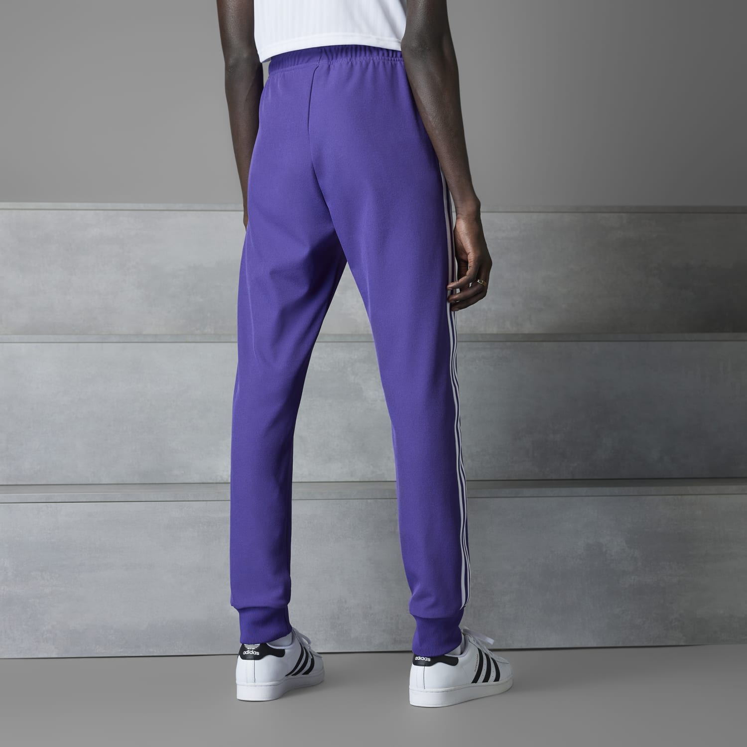 Model wearing Real Madrid Icon track pants in an outdoor setting, perfect for sports and casual wear.