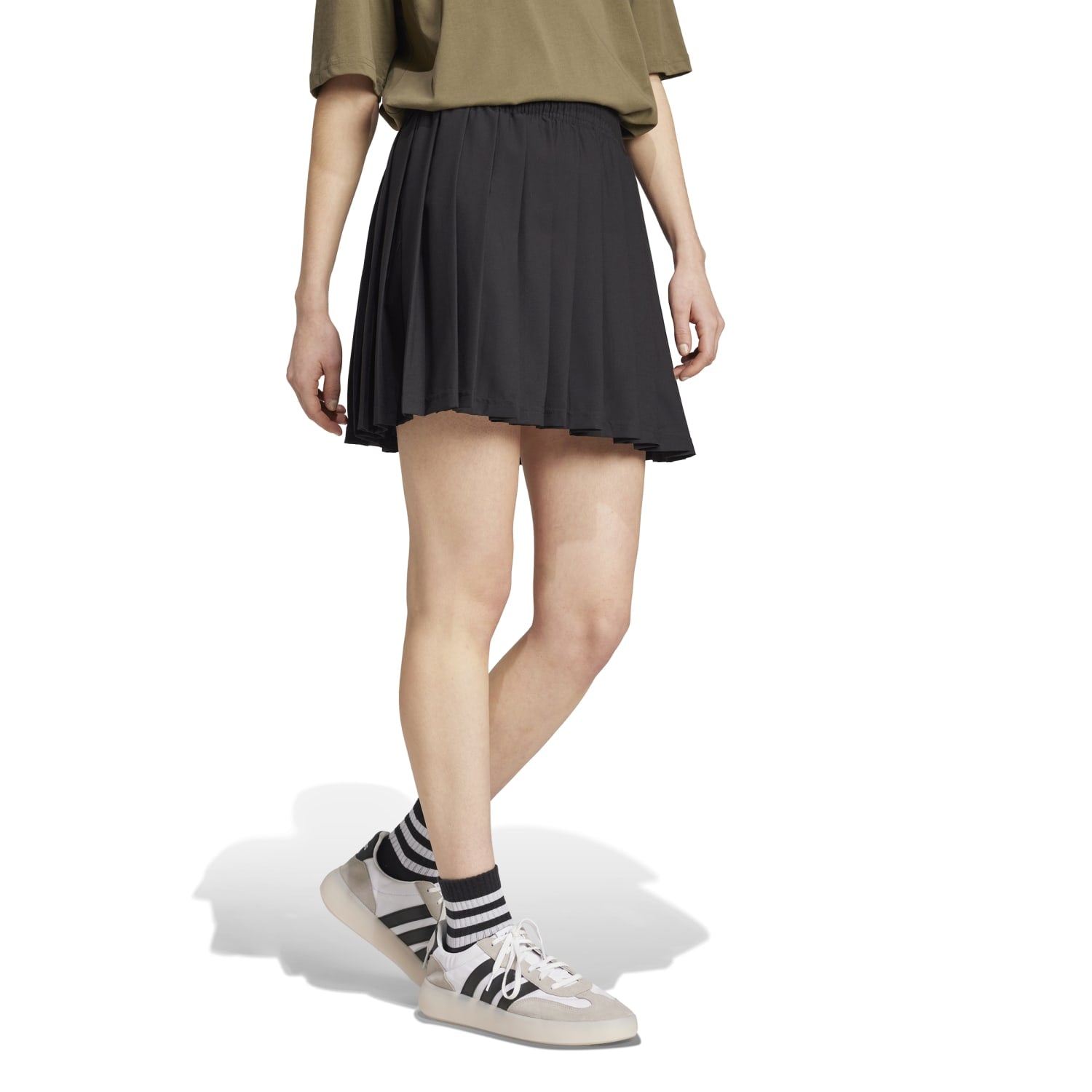 Model wearing the Tiro Pleated Skirt at a summer picnic, highlighting its flowy fabric.