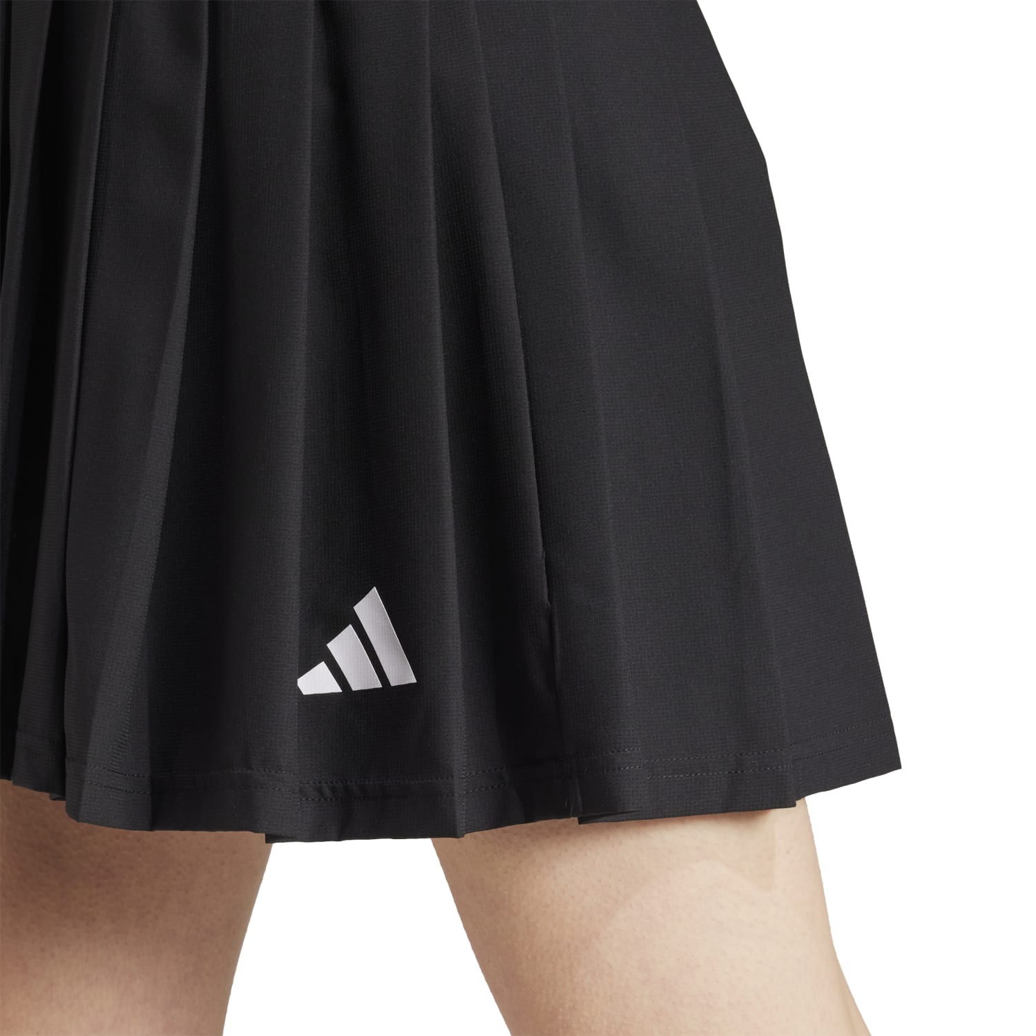 Model wearing the Tiro Pleated Skirt at a summer picnic, highlighting its flowy fabric.