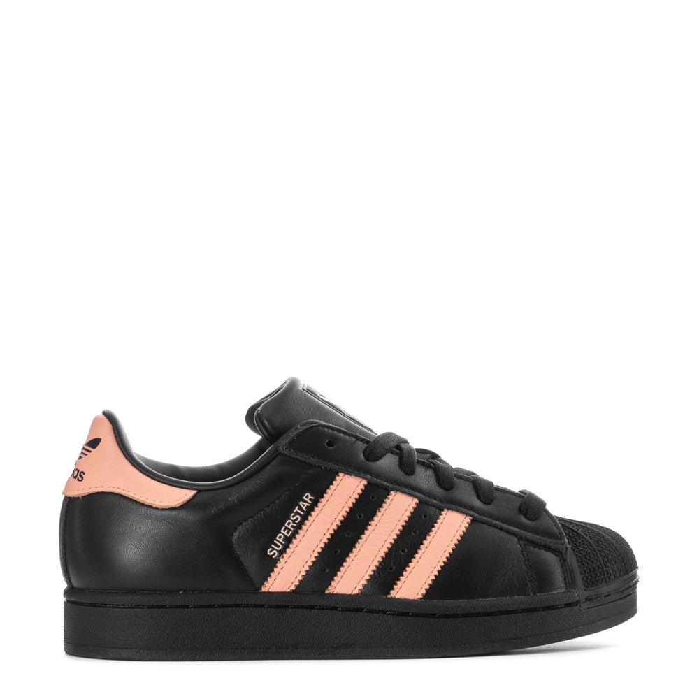 Adidas Superstar women's sneakers from the side, highlighting the sleek leather design.