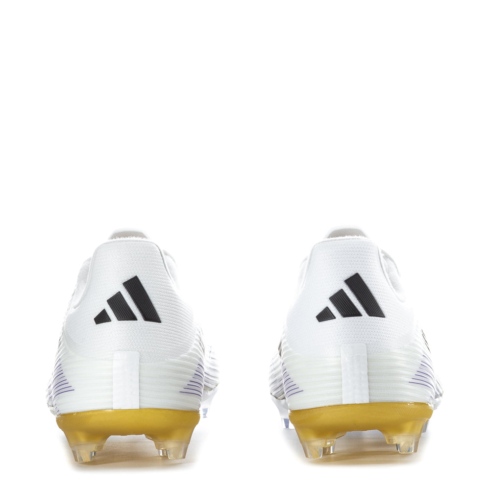 Side angle of player planting foot in F50 League FGxMG, highlighting multi-ground studs gripping firm natural grass