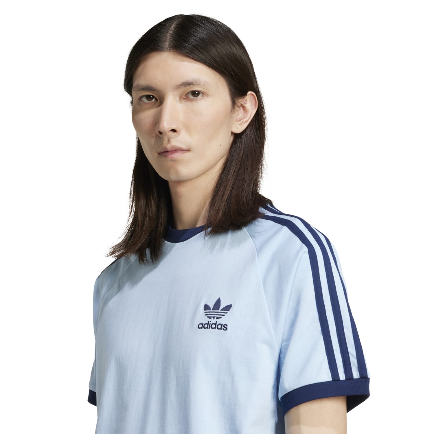 Front view of slim fit adidas 3-stripe tee showing embroidered Trefoil logo and contrast hem on wooden table