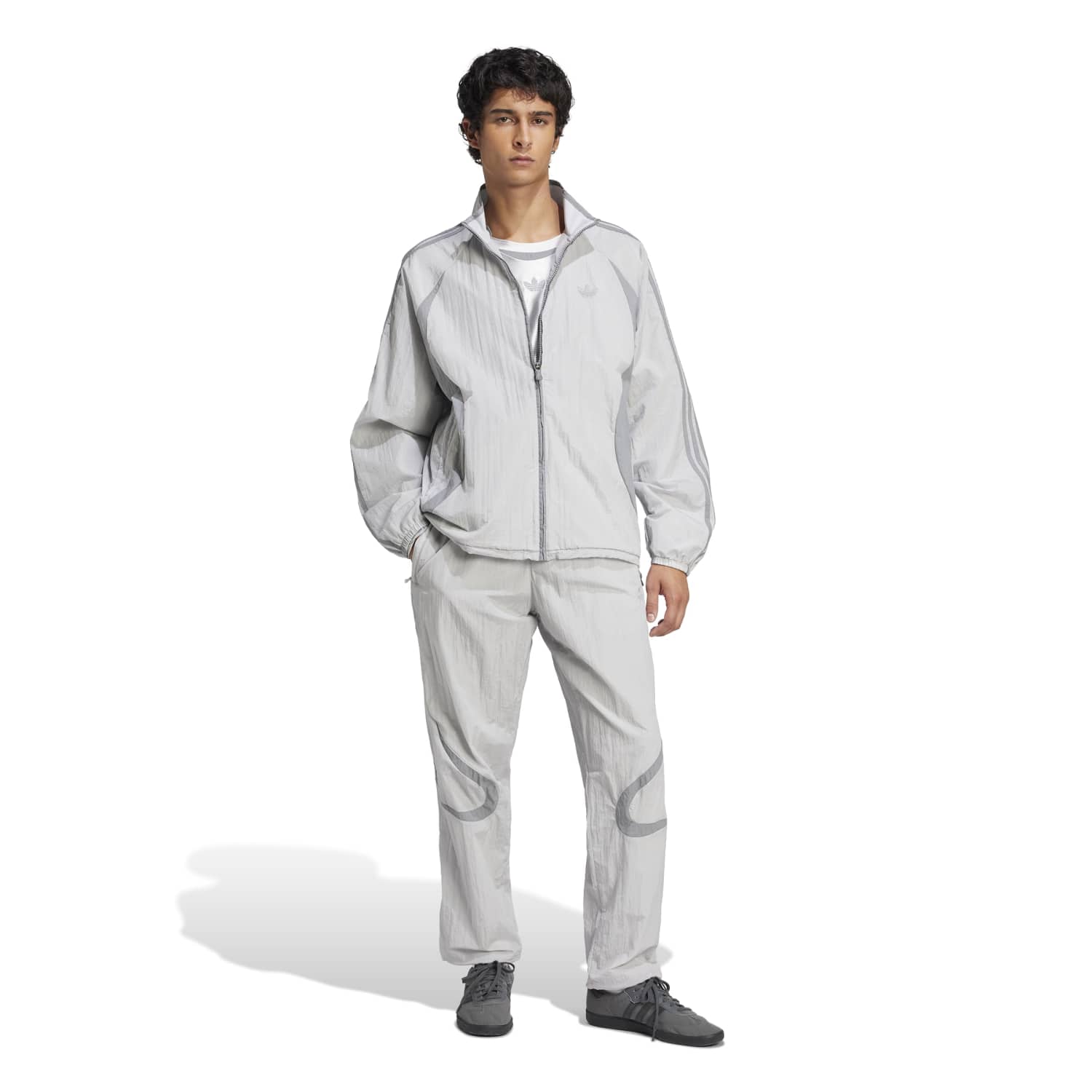 Man wearing the Adicolor Vintage Woven Track Jacket during a casual outing, demonstrating its style and versatility.