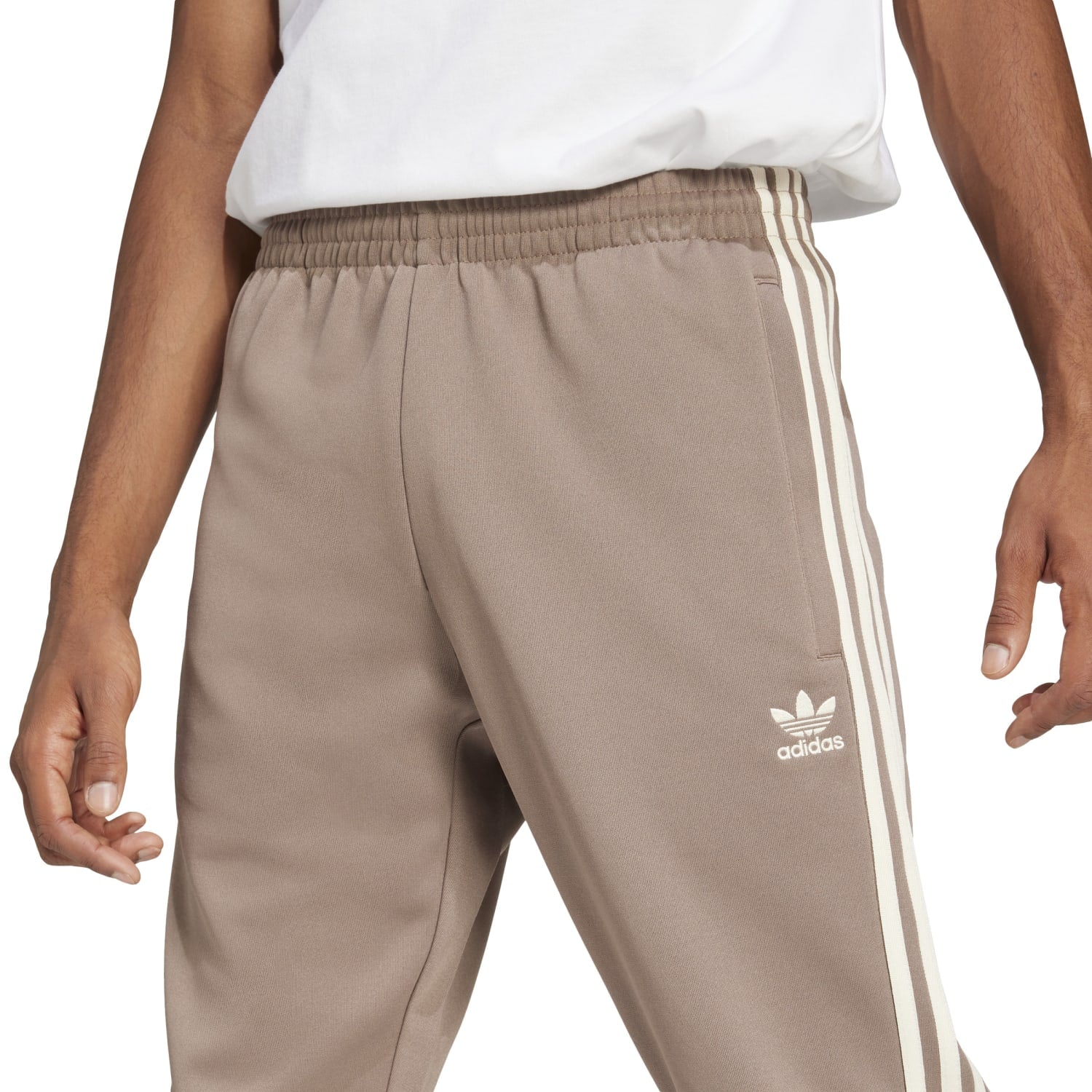Close-up of the Adidas Superstar Slim Fit Track Pants showing the elastic waistband and stylish design.