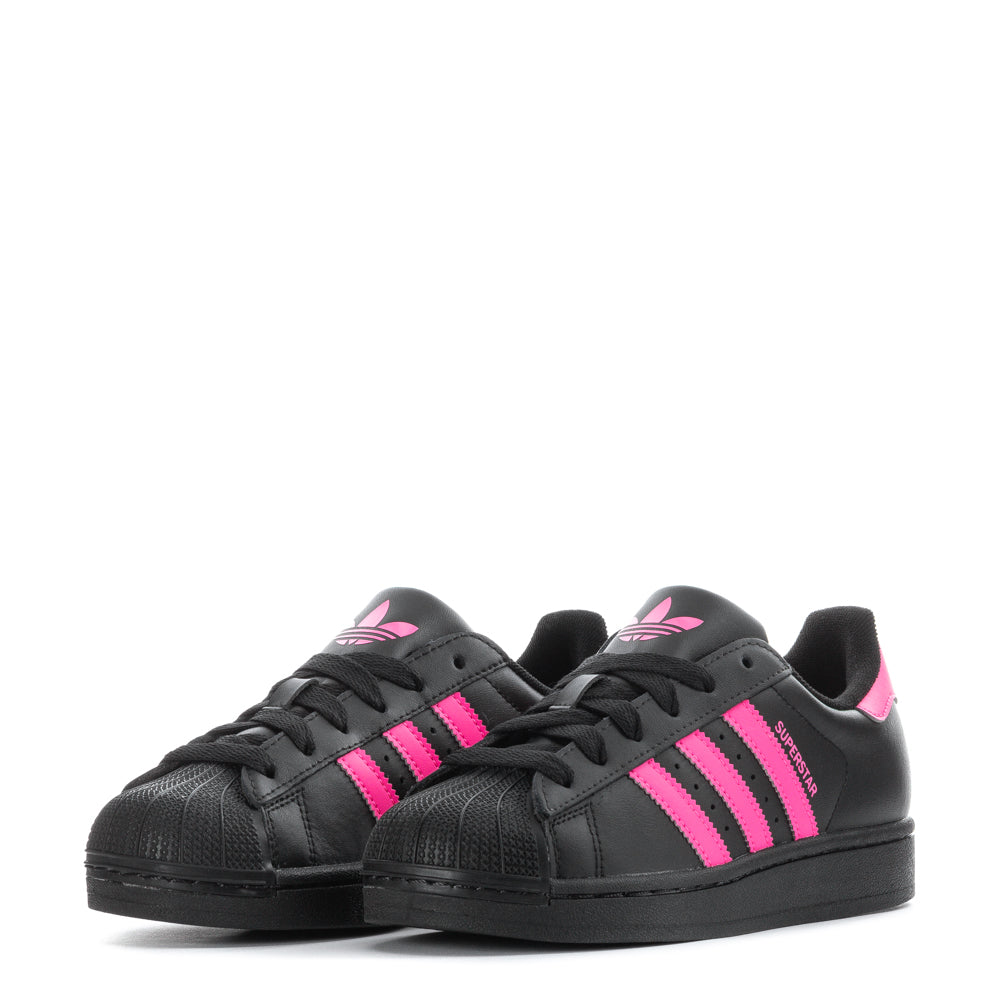 Adidas Superstar Youth Sneakers on a playground, demonstrating durability and grip.