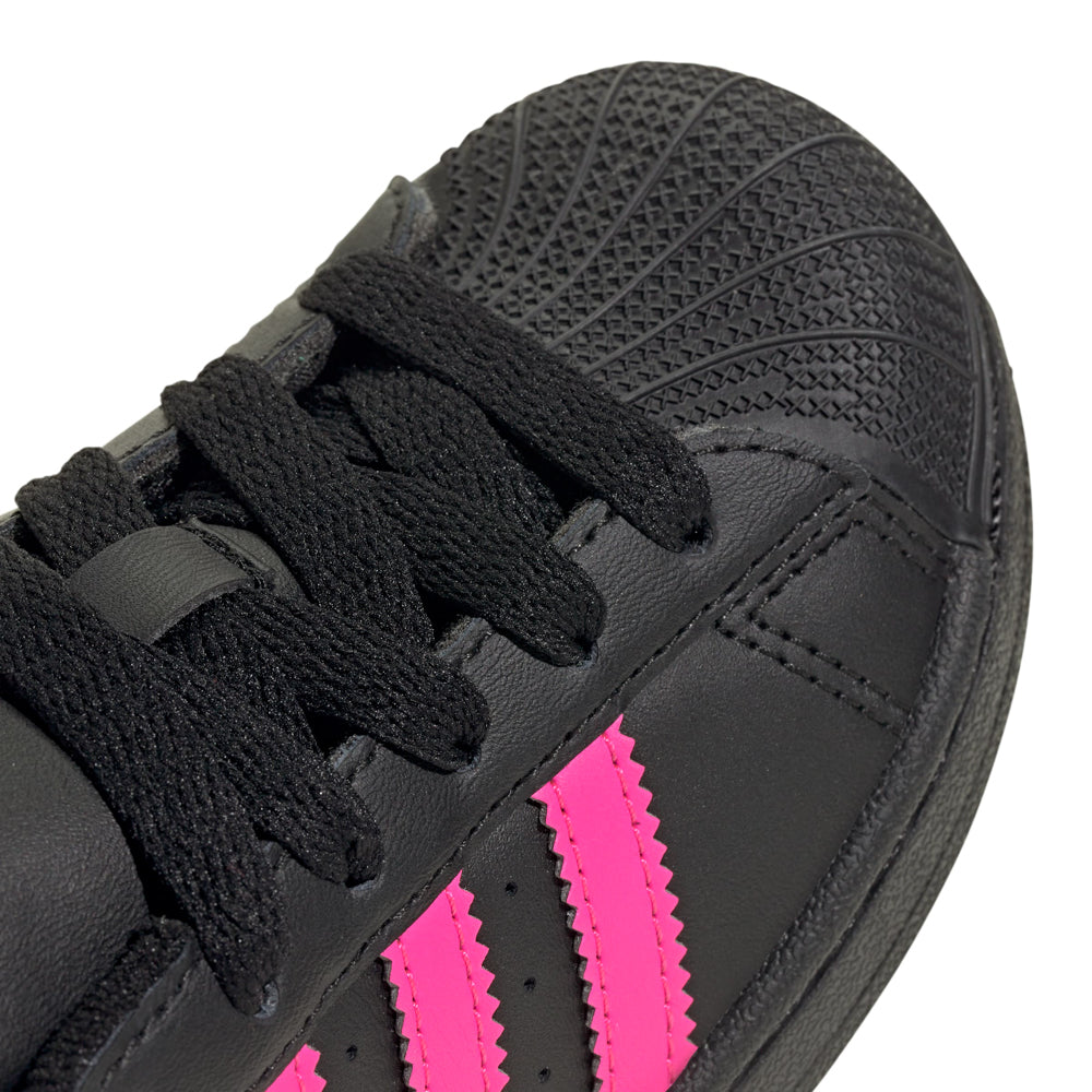 Adidas Superstar II kids sneakers worn by a child, showcasing their stylish design during playtime.