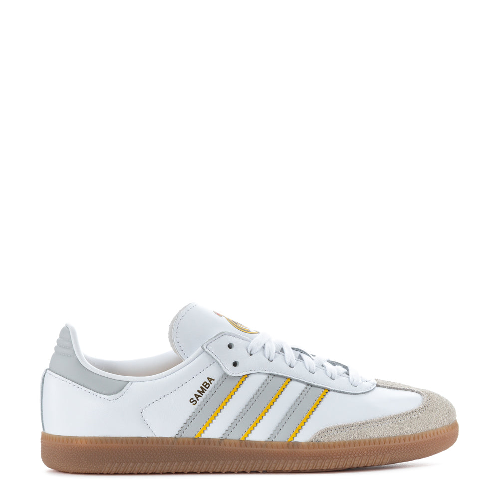 Top-down view of white adidas Samba OG against concrete, showing the iconic serrated 3-Stripes and stitched leather panels