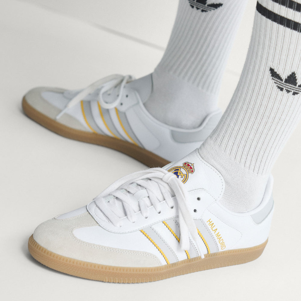 Side profile of Samba OG on-foot with cuffed denim, highlighting the slim silhouette and gum rubber cupsole