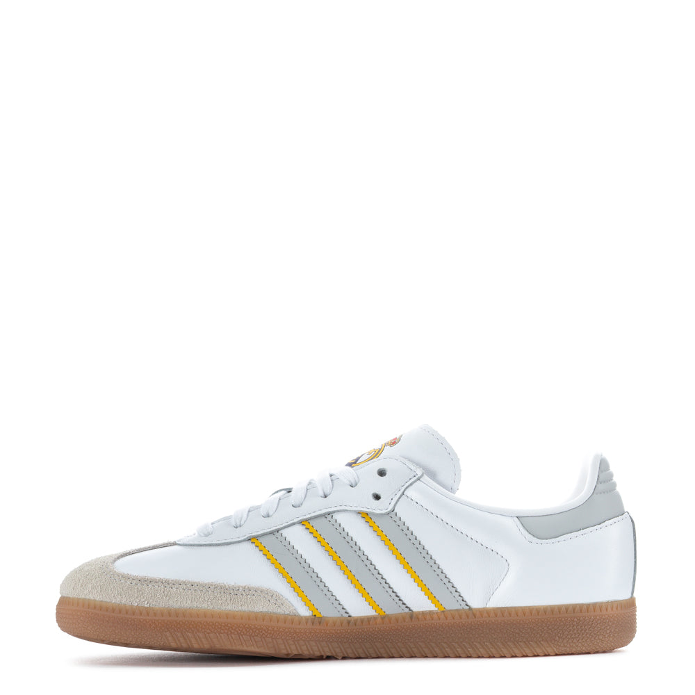 Top-down view of white adidas Samba OG against concrete, showing the iconic serrated 3-Stripes and stitched leather panels