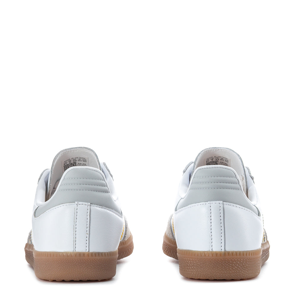 Top-down view of white adidas Samba OG against concrete, showing the iconic serrated 3-Stripes and stitched leather panels