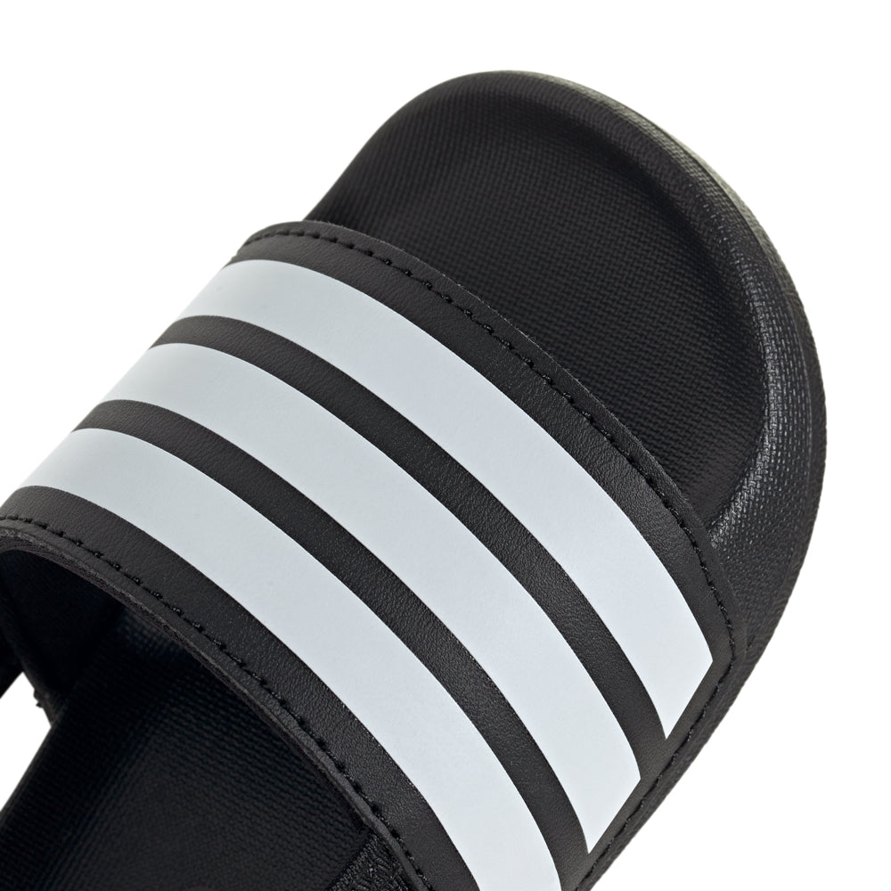 Side view of Adilette Estrap toddler slides on a playful child