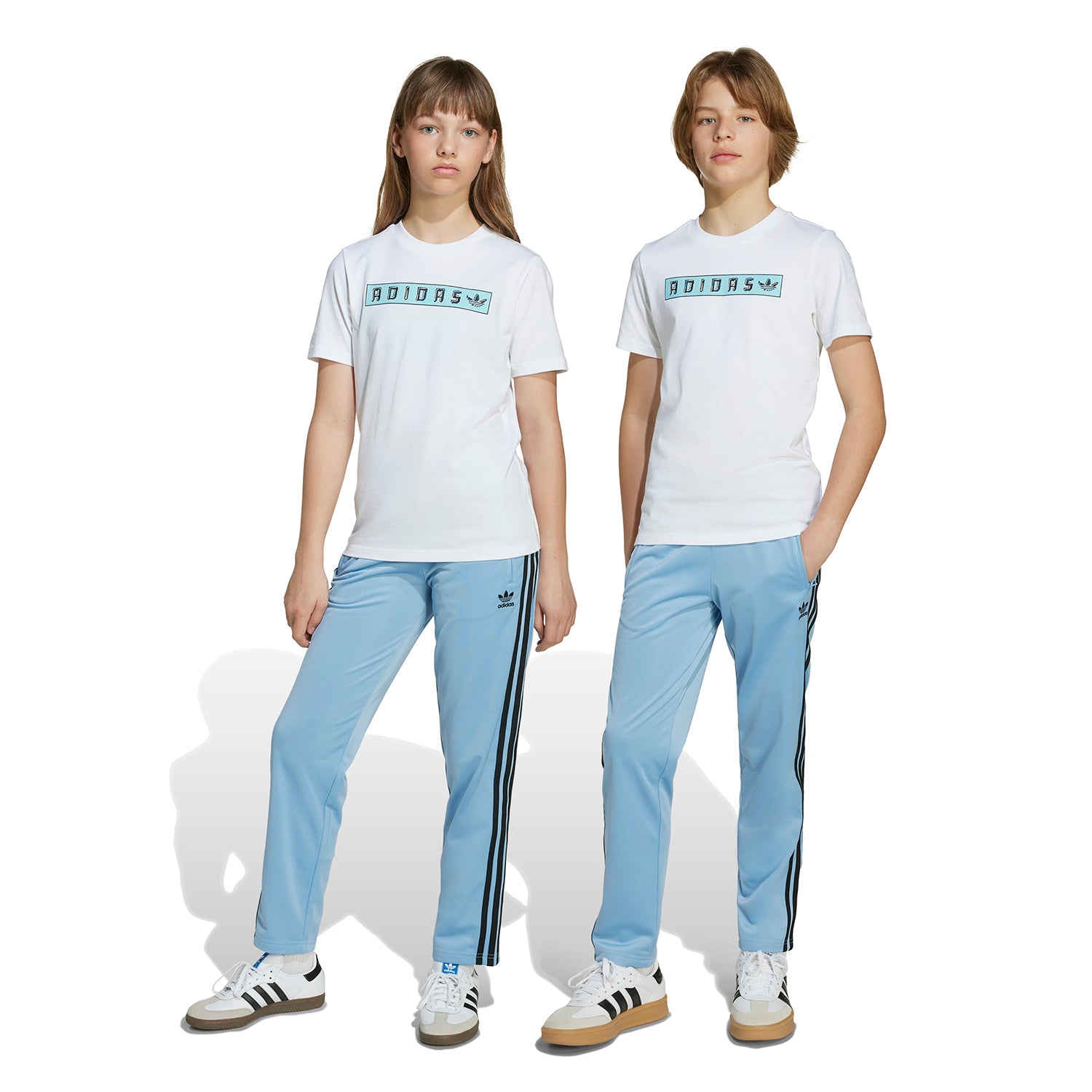 Adidas Firebird youth track pants displayed in a sporty setting, perfect for young athletes.