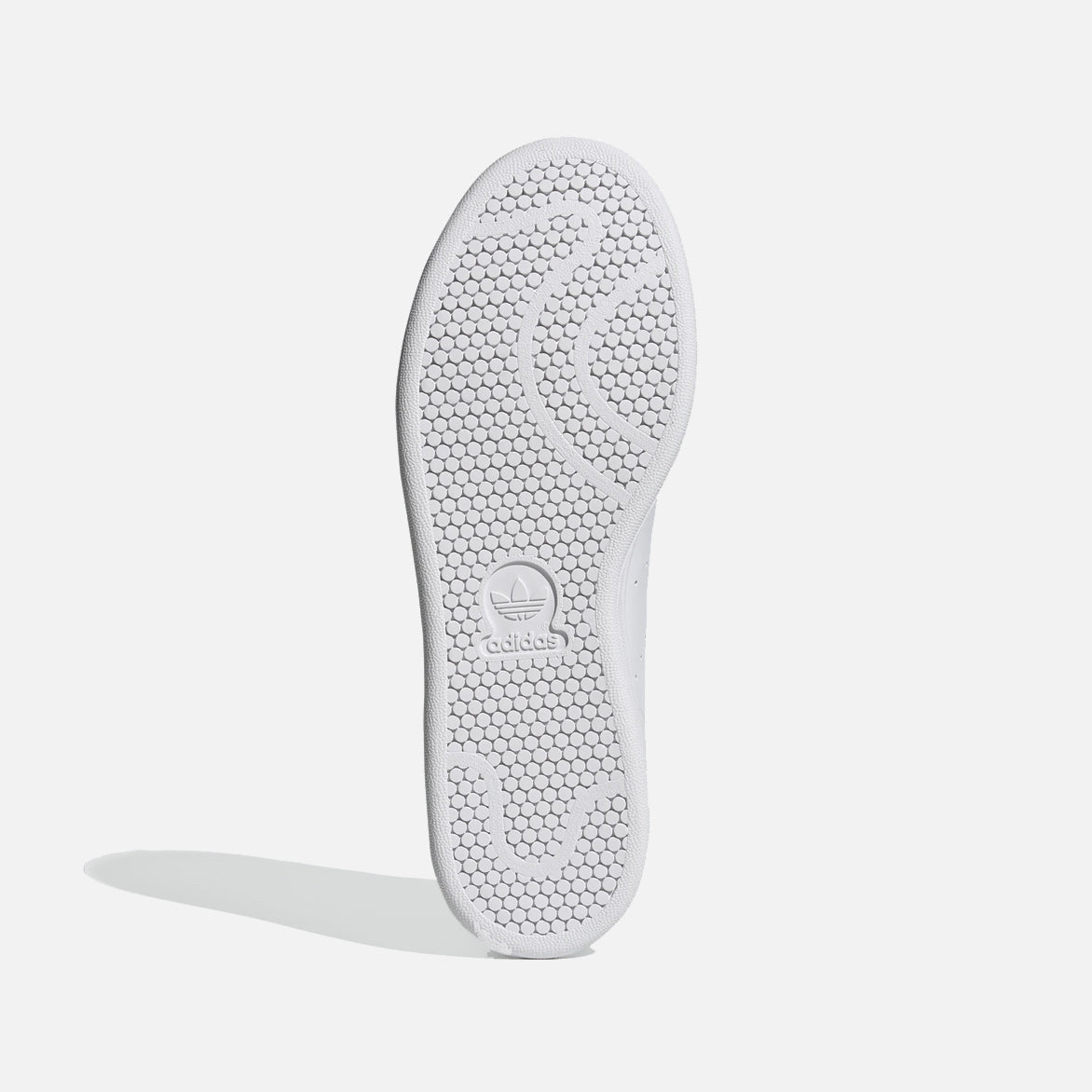 Close-up of the navy heel tab on Adidas Stan Smith sneakers.