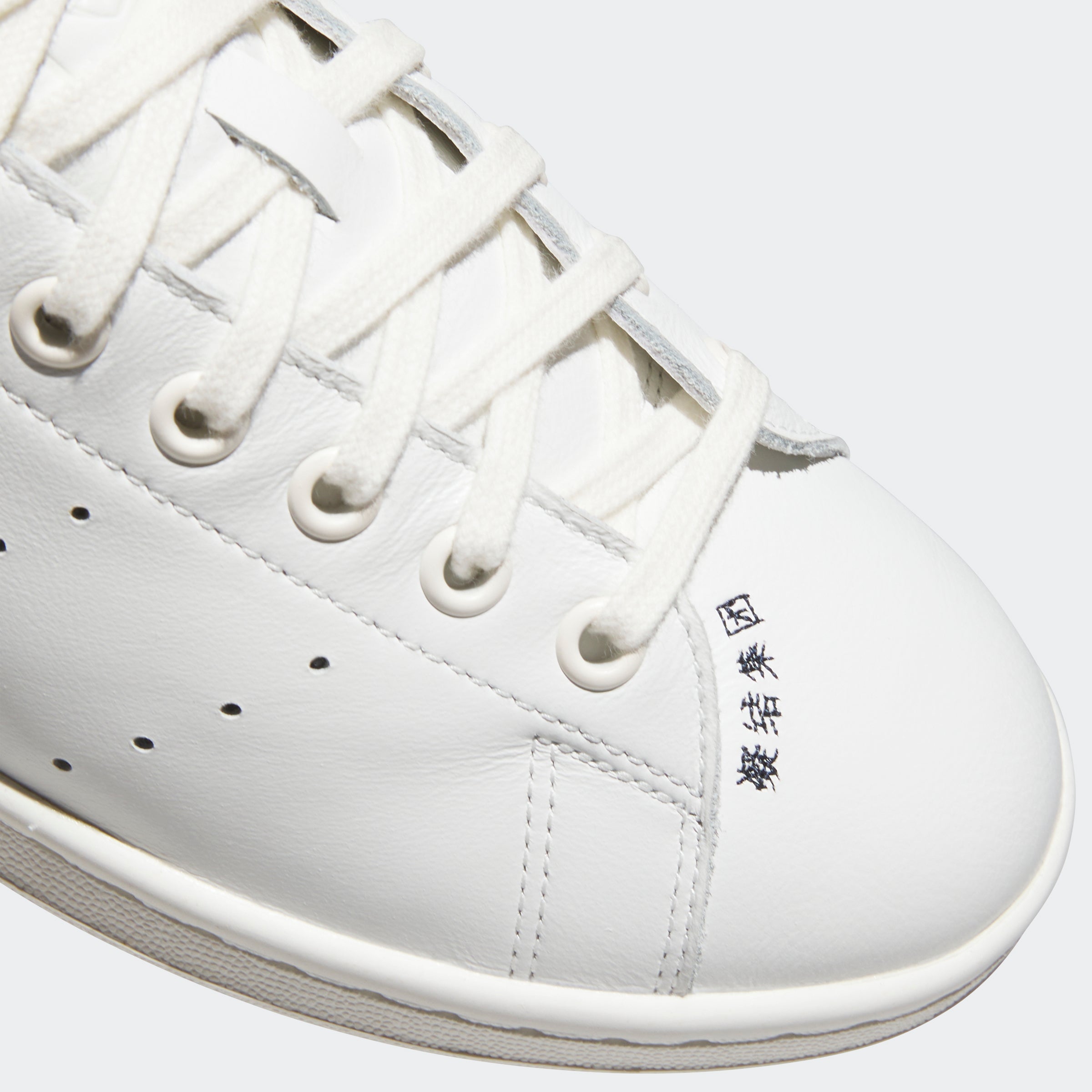 Close-up of the premium leather upper and embossed logo on CLOT sneakers