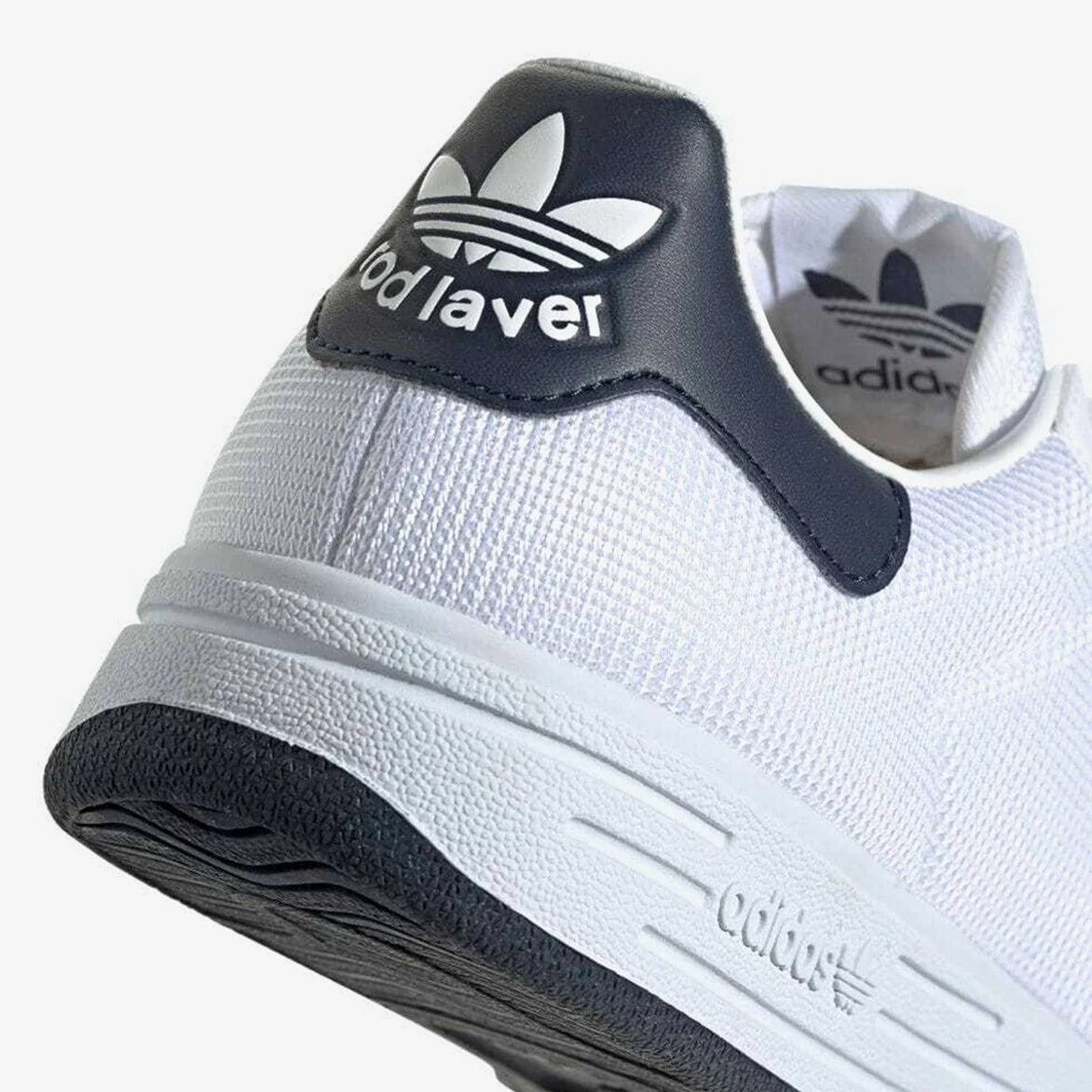 Adidas Rod Laver sneakers side view highlighting the white mesh and navy accents.