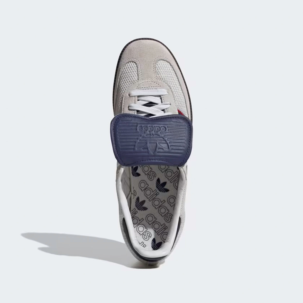 Top-down shot of adidas samba og crystal white dark blue gum sole on wooden floor with natural light