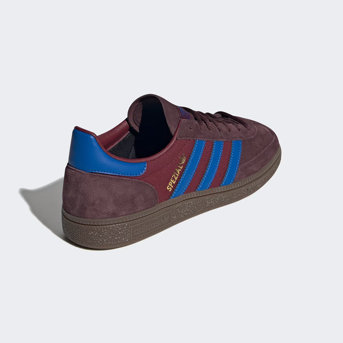 Close-up of Adidas Handball Spezial Night Red sneakers highlighting the suede texture and blue leather details.