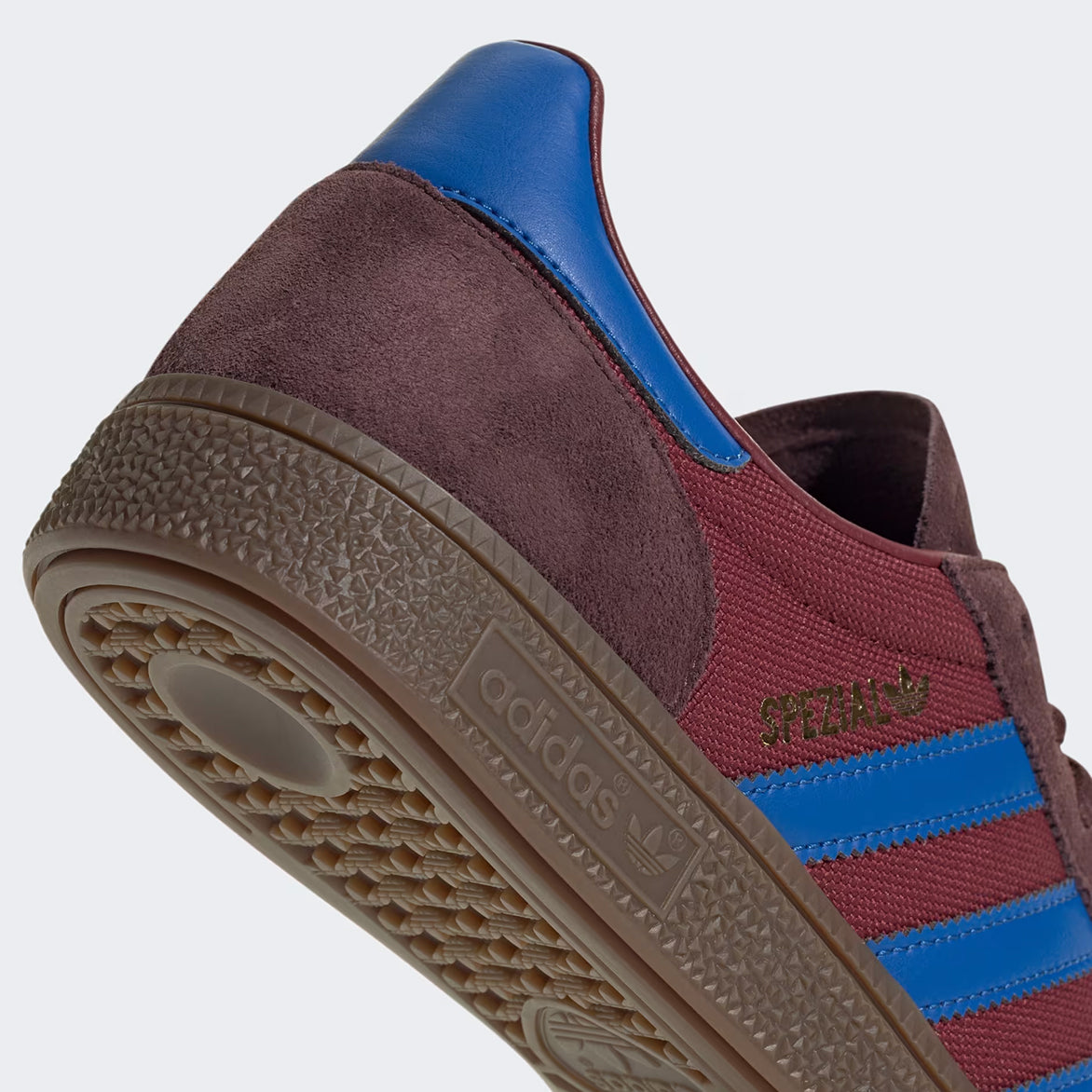 Close-up of Adidas Handball Spezial Night Red sneakers highlighting the suede texture and blue leather details.