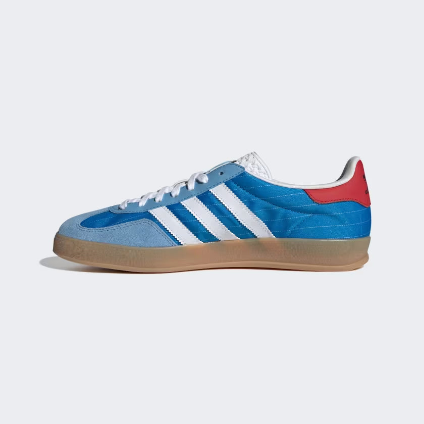 Close-up shot of the Adidas Gazelle Indoor bright blue sneakers showcasing the red leather heel and Trefoil logo on the tongue.