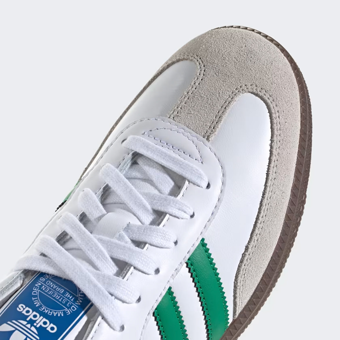 Side angle of Adidas Samba OG Cloud White Green limited edition sneakers on concrete