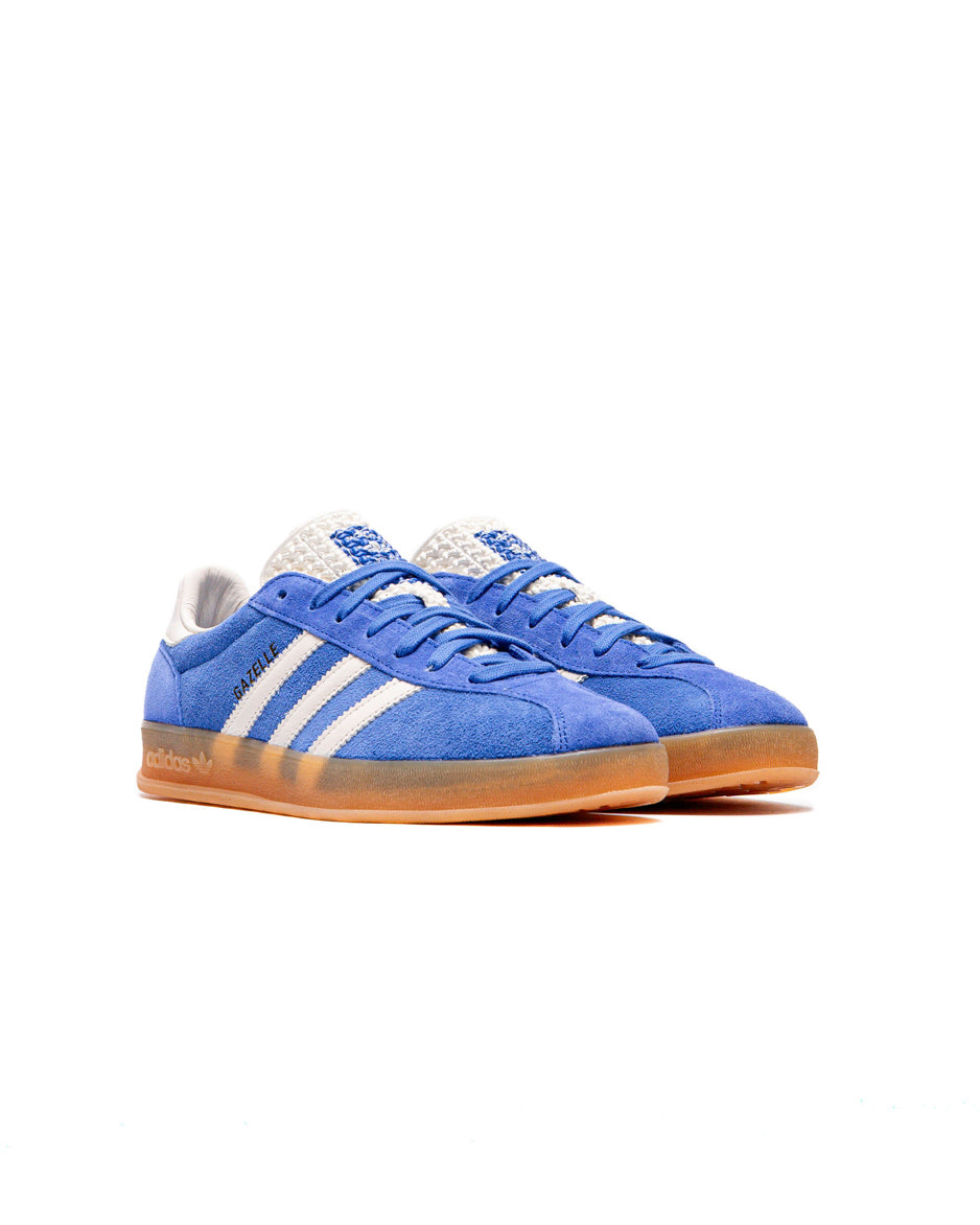 Top-down shot of the sneakers showing the blue laces and textured tongue with branding